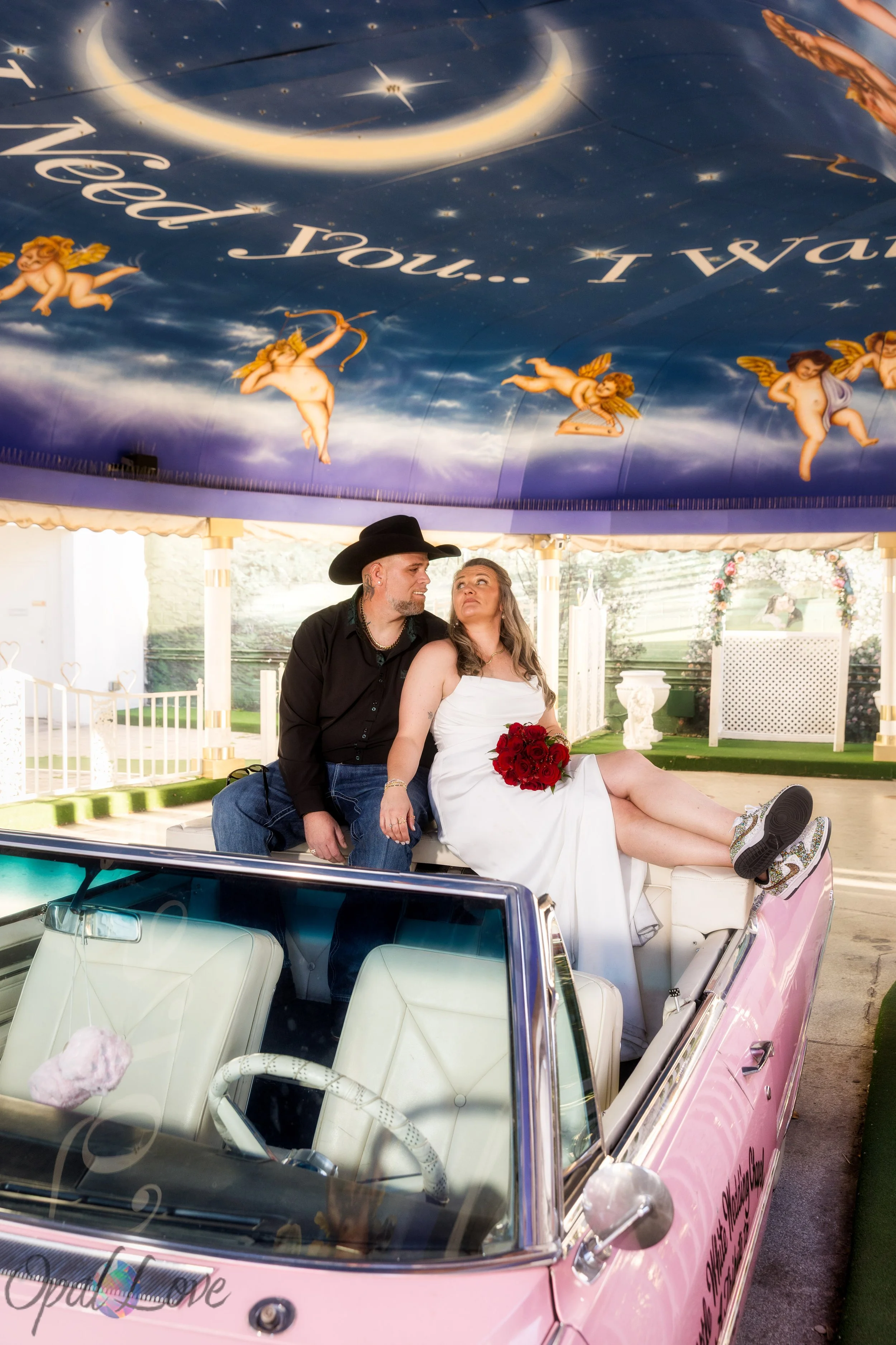 Couple sitting in pink Cadillac at Little White Wedding Chapel in Las Vegas