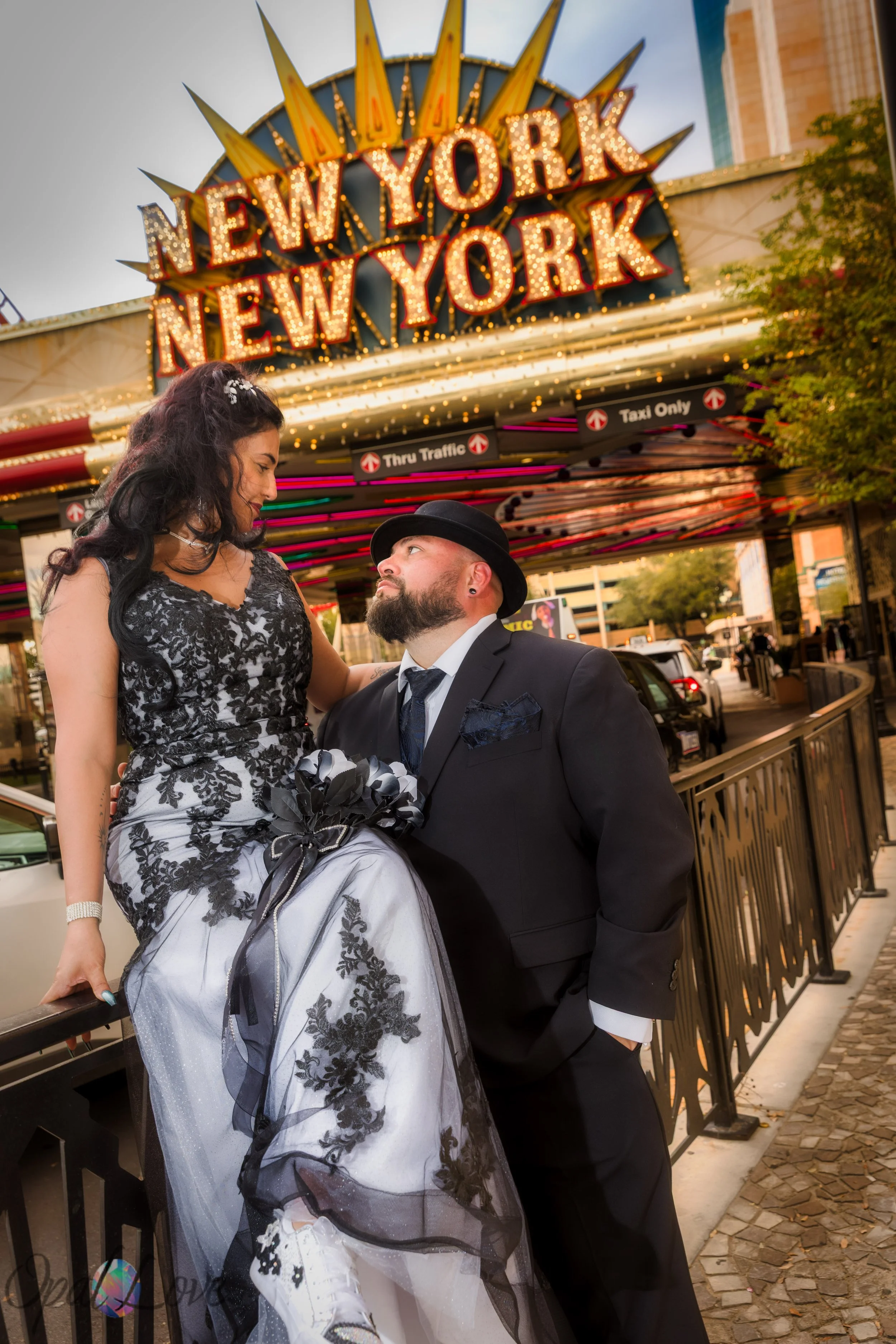 Groom holding bride while standing under the New York New York marquee lights.