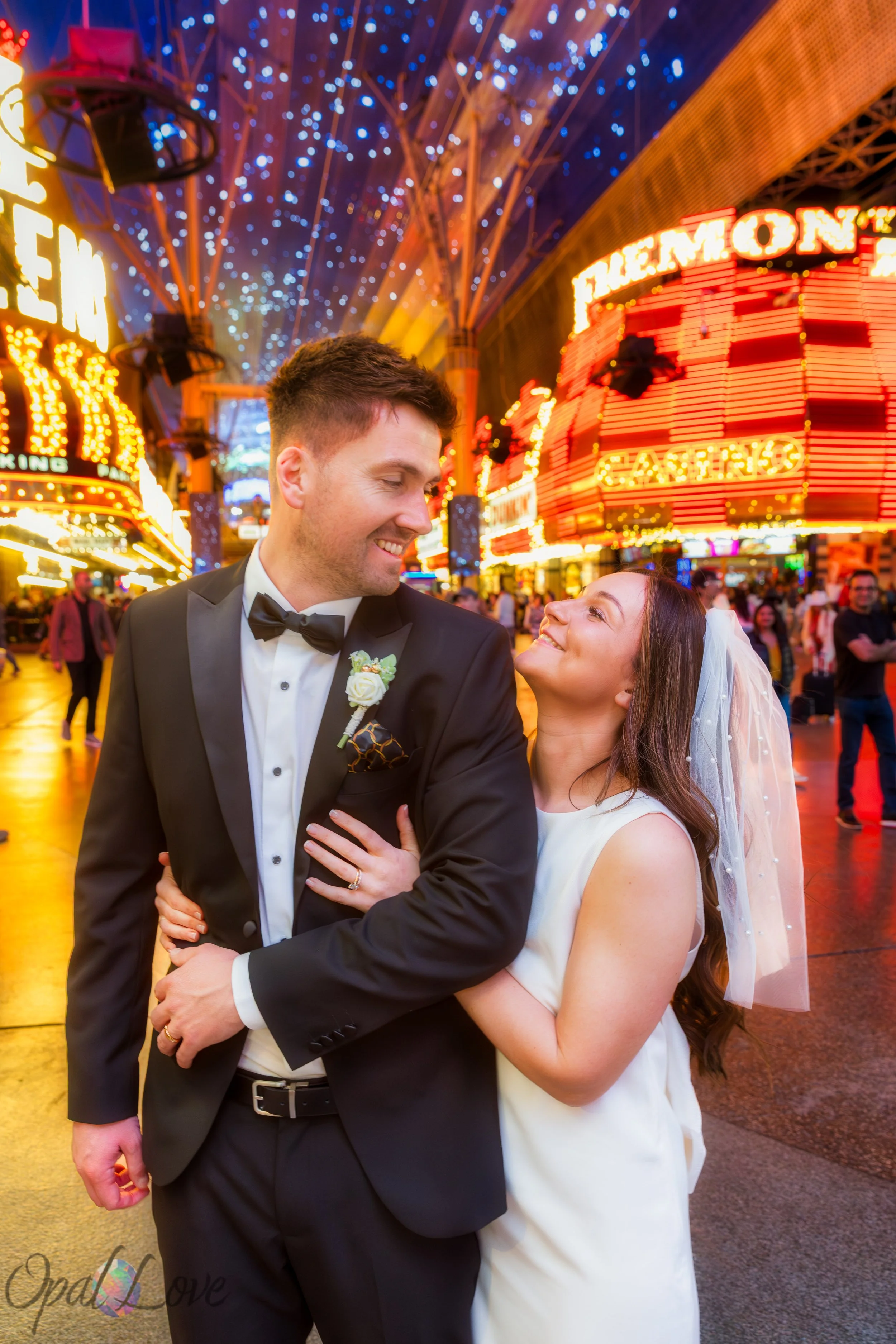 Bride and groom smiling together under Fremont Street canopy lights in Downtown Las Vegas