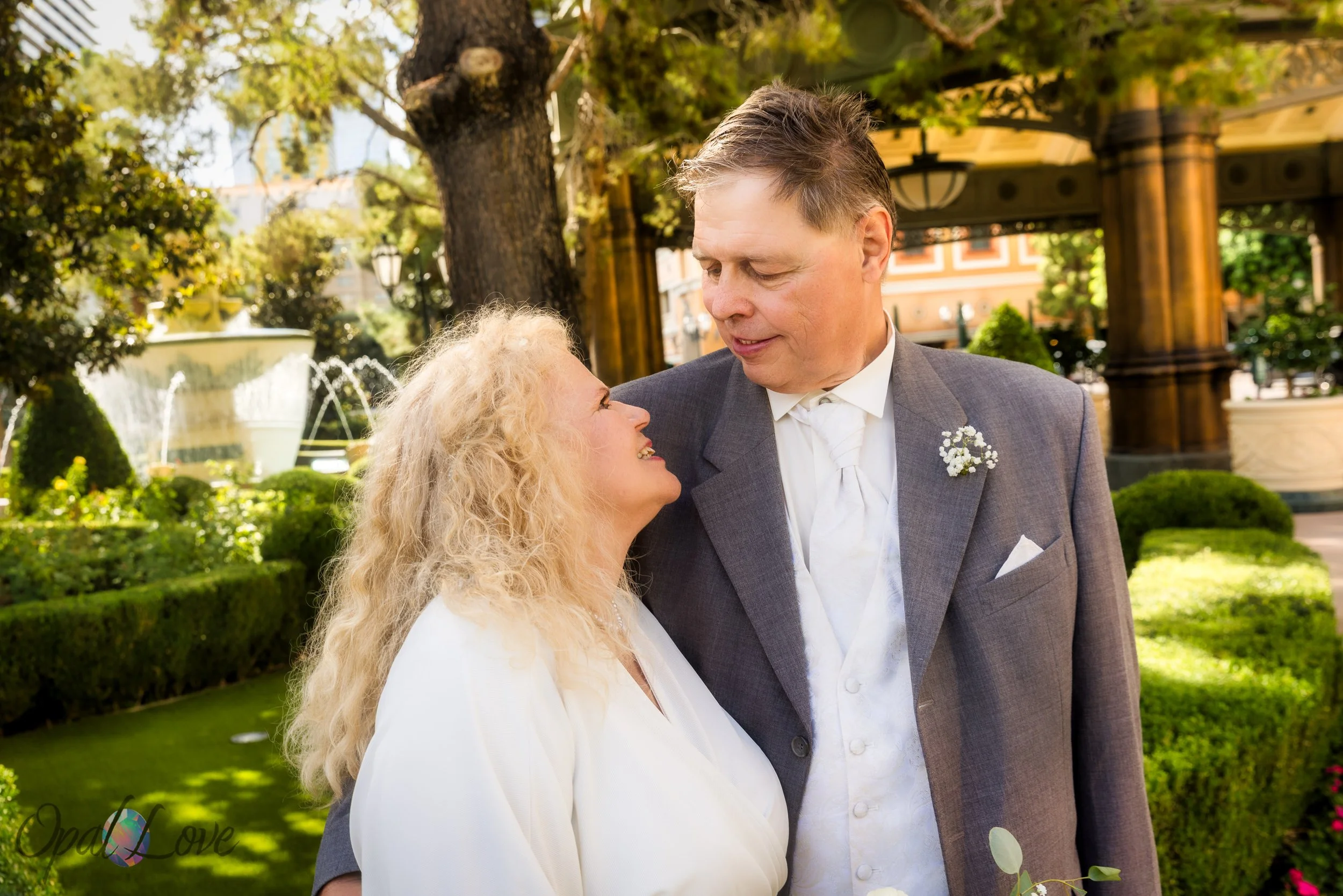 Couple smiling together in Bellagio garden after Las Vegas elopement