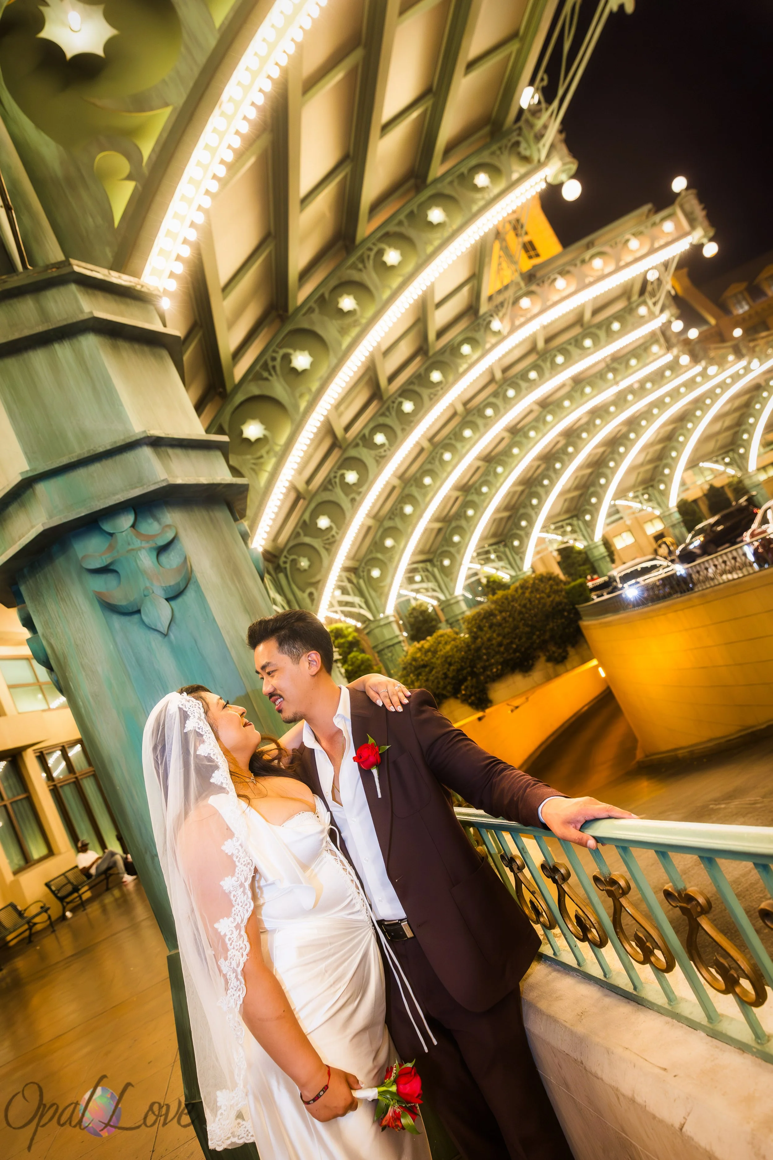 Couple sharing a quiet moment along the Paris Las Vegas walkway surrounded by warm golden lights.