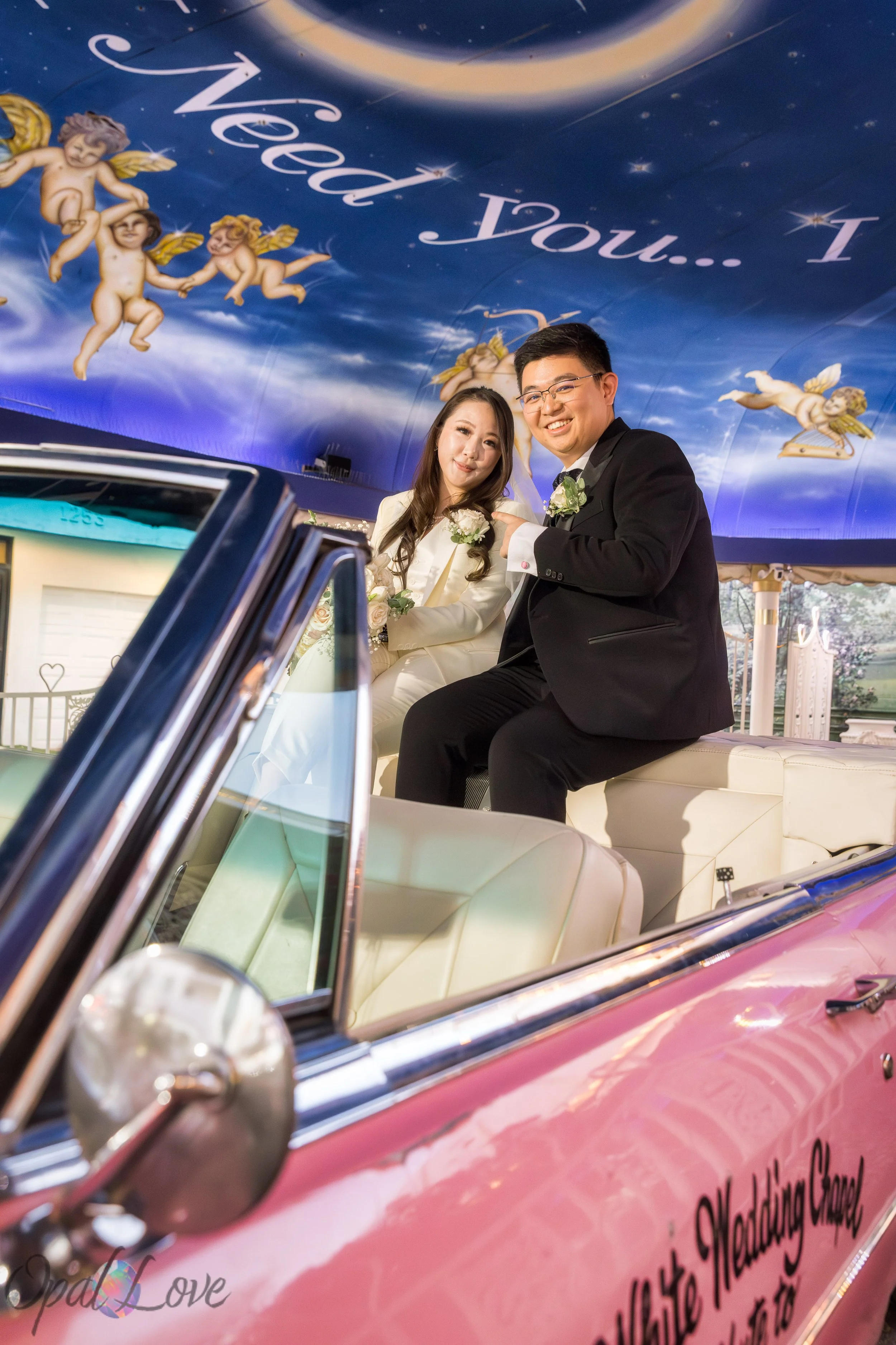 Couple sitting in Pink Cadillac inside Little White Wedding Chapel tunnel of love
