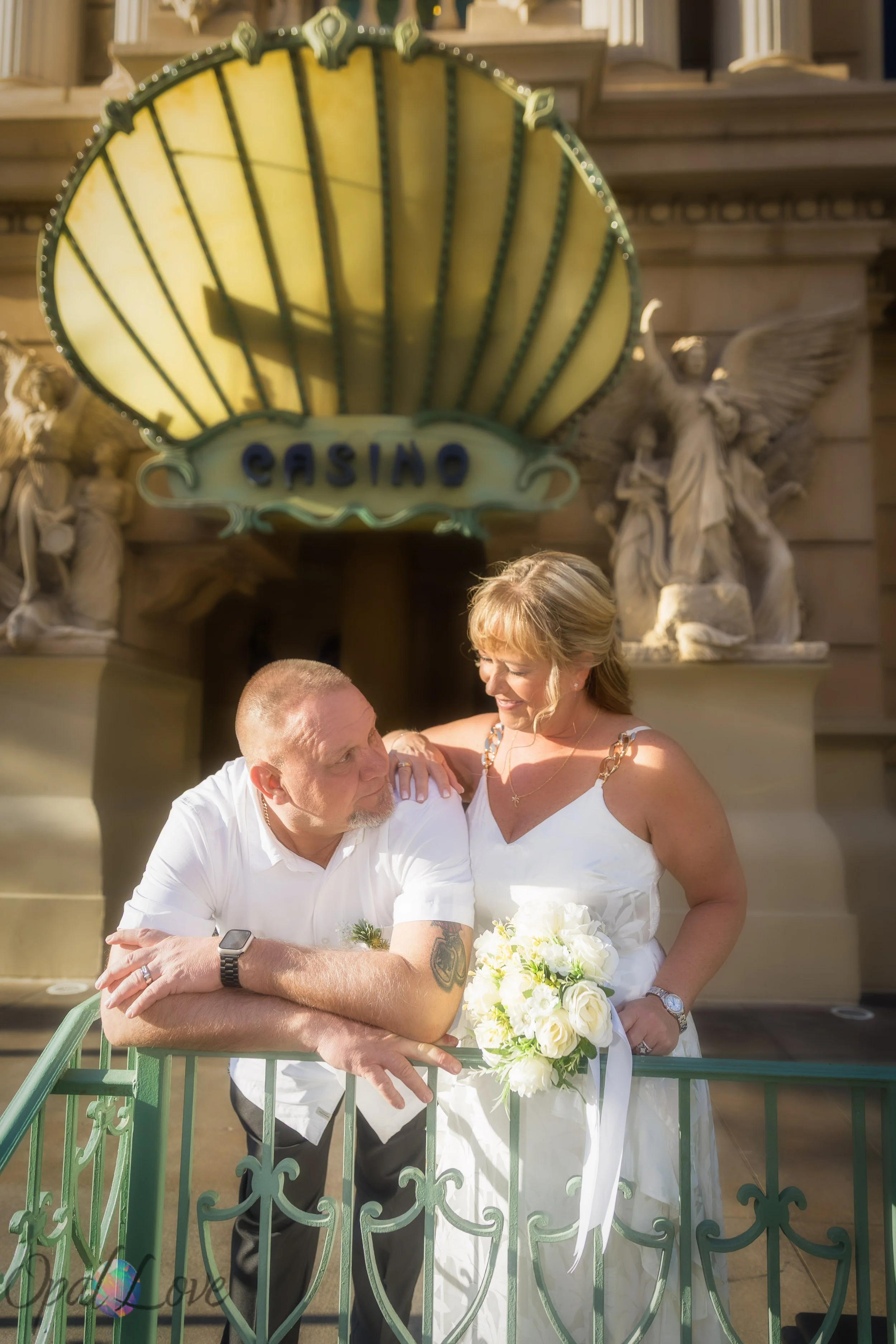 Bride and groom posing near the Paris Las Vegas casino entrance with soft golden light during their wedding day.