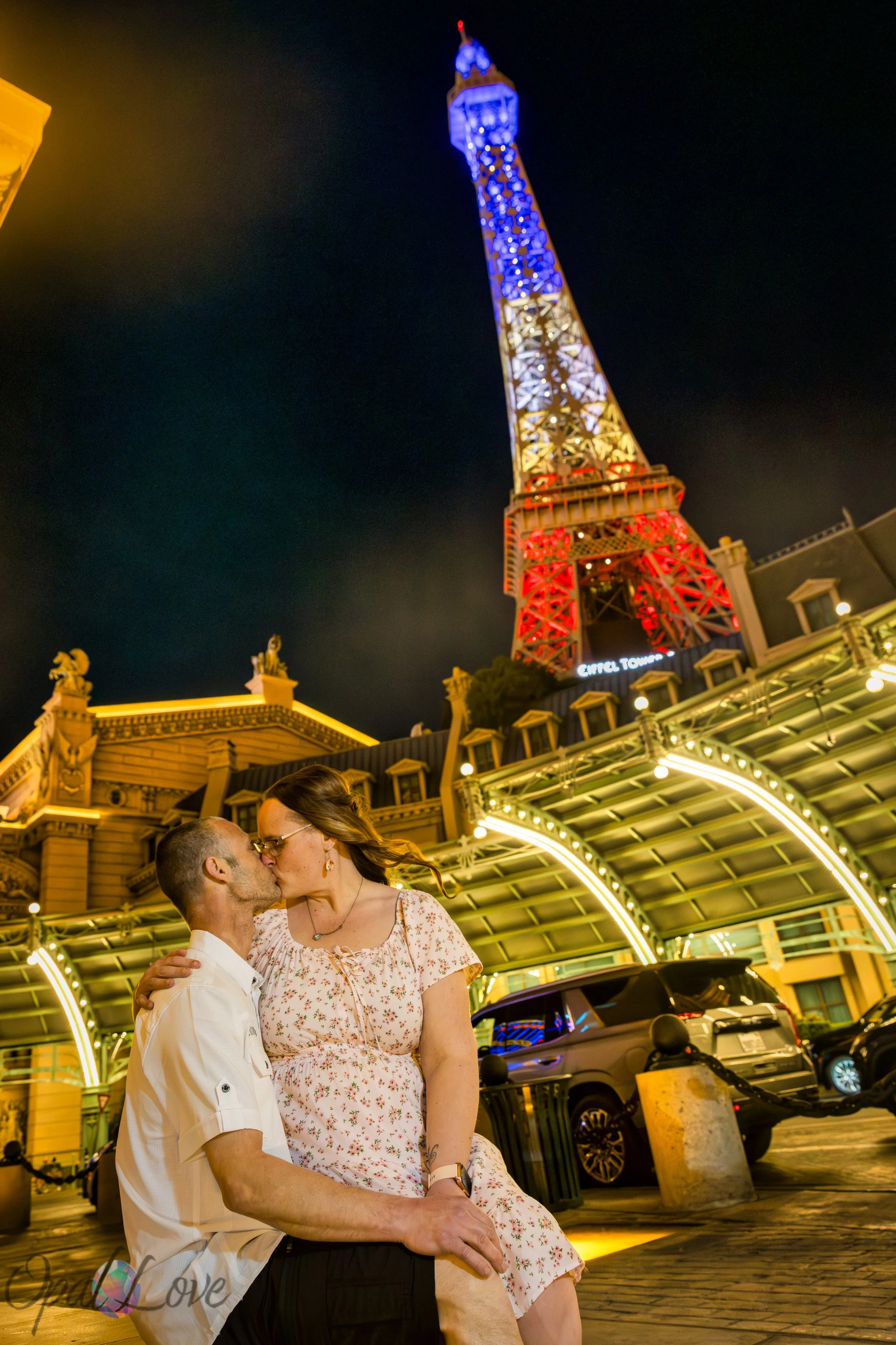 : Couple kissing beneath the glowing Eiffel Tower during a Las Vegas Strip anniversary session.