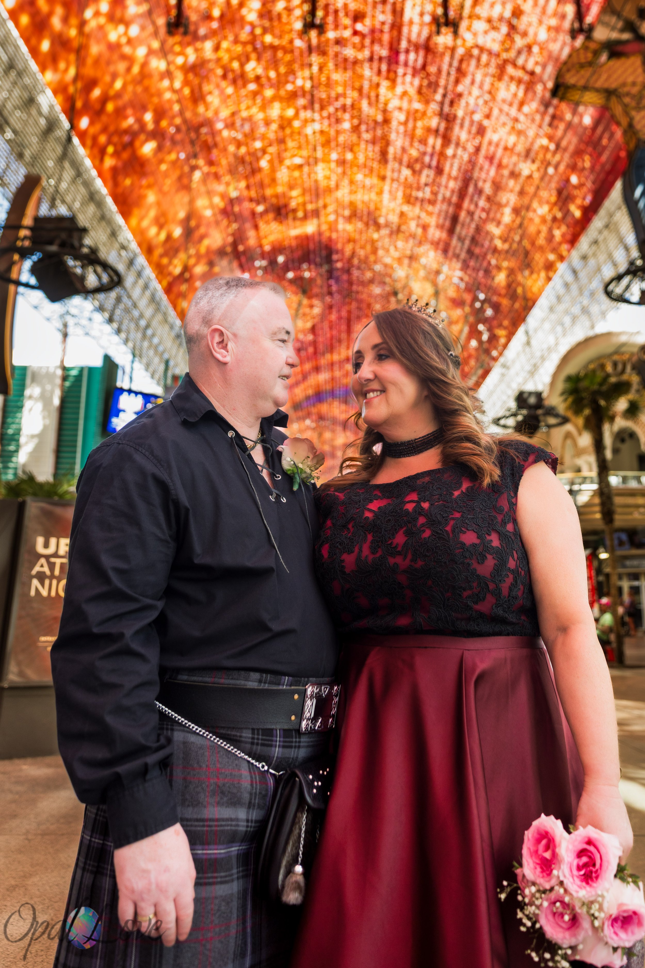 Bride and groom standing beneath the Fremont Street Experience canopy in Downtown Las Vegas.