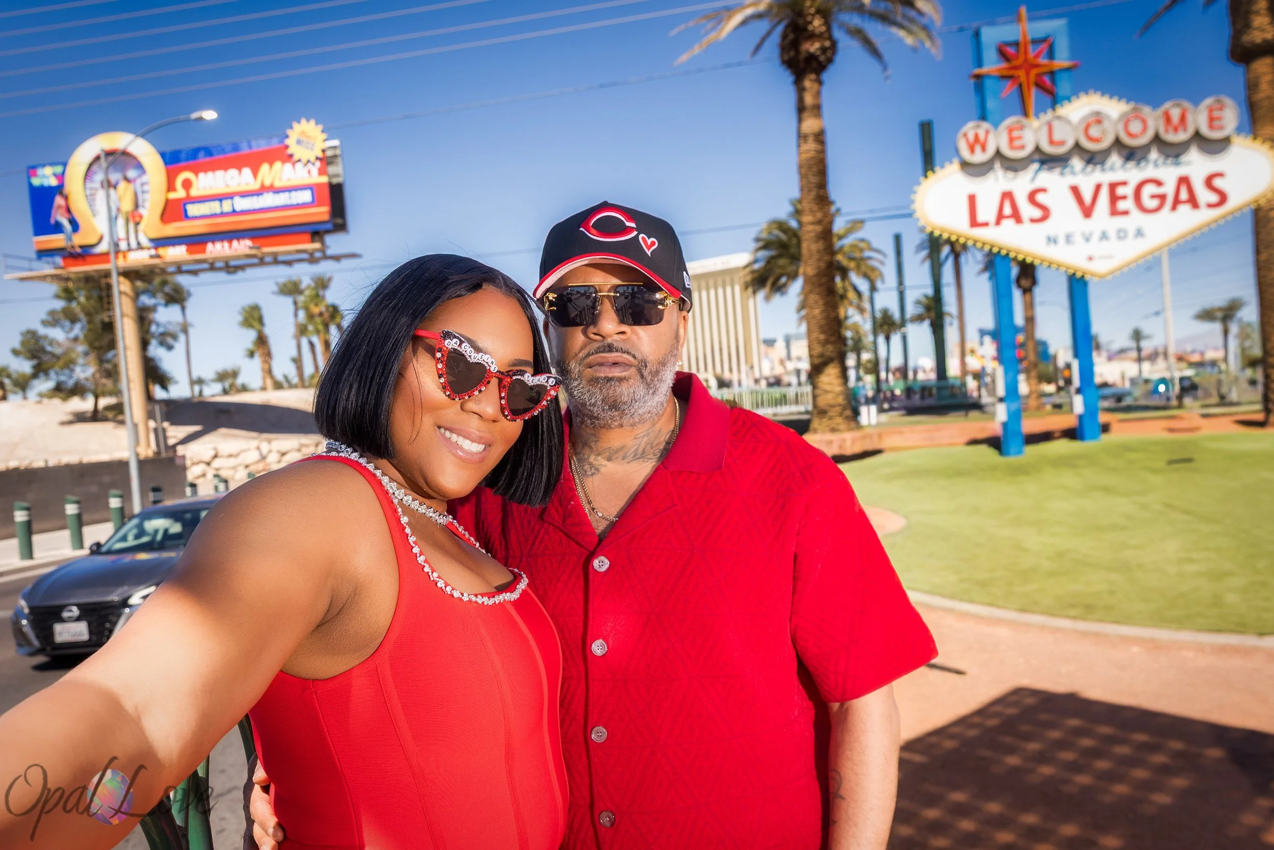 Couple posing together with the Welcome to Las Vegas sign behind them during their Las Vegas anniversary celebration.