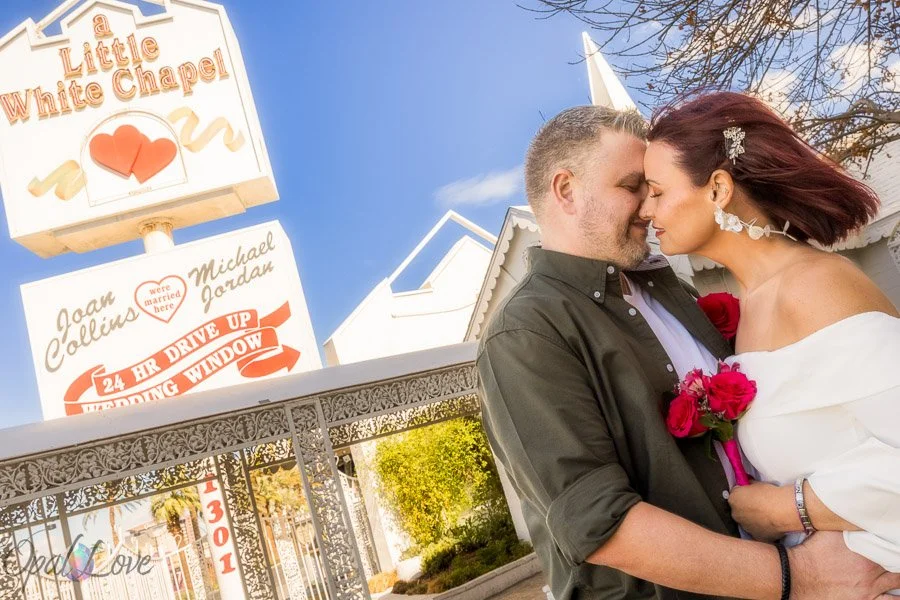 Newlywed couple embracing outside the Little White Wedding Chapel in Las Vegas.
