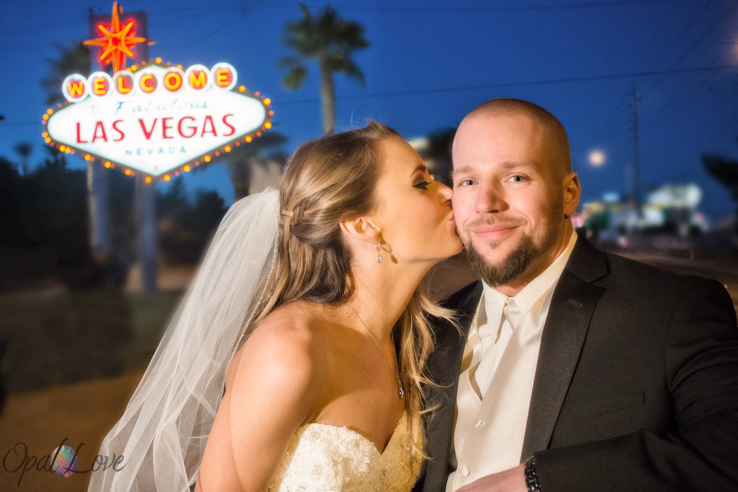 Bride kisses her partner beside the Welcome to Fabulous Las Vegas sign