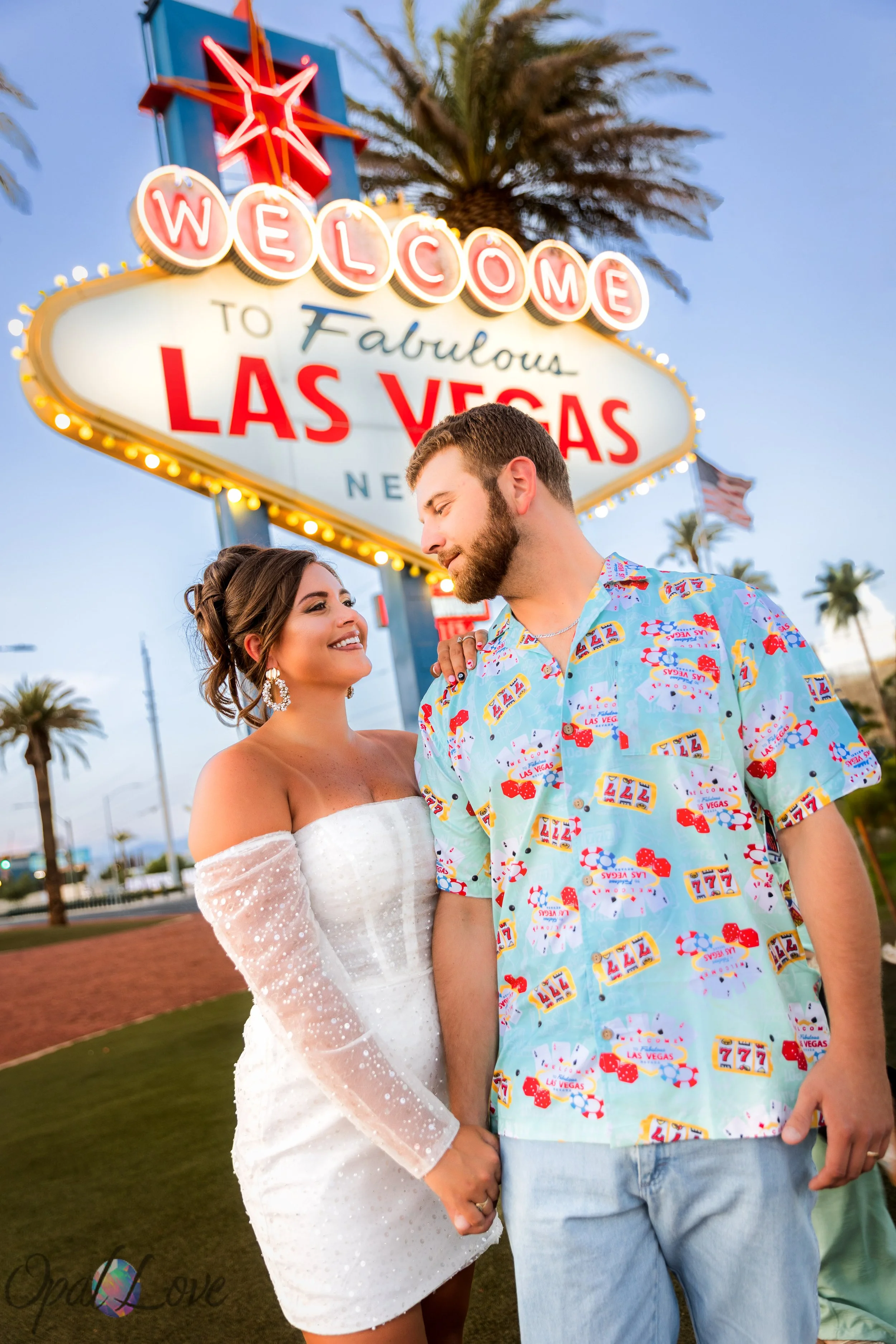 Photographer capturing couple at Las Vegas sign during photo tour