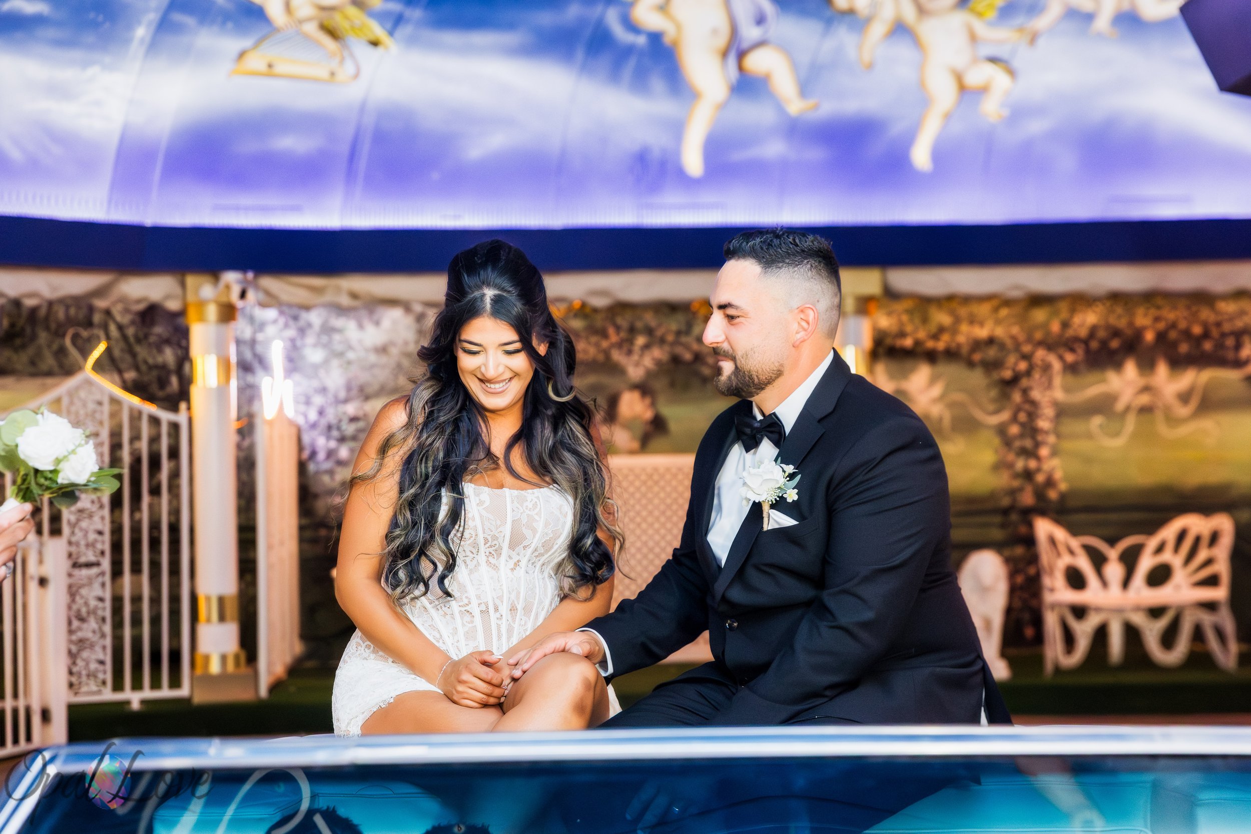 Newlyweds Alysha and Justin sitting together in the pink Cadillac at the Little White Wedding Chapel.