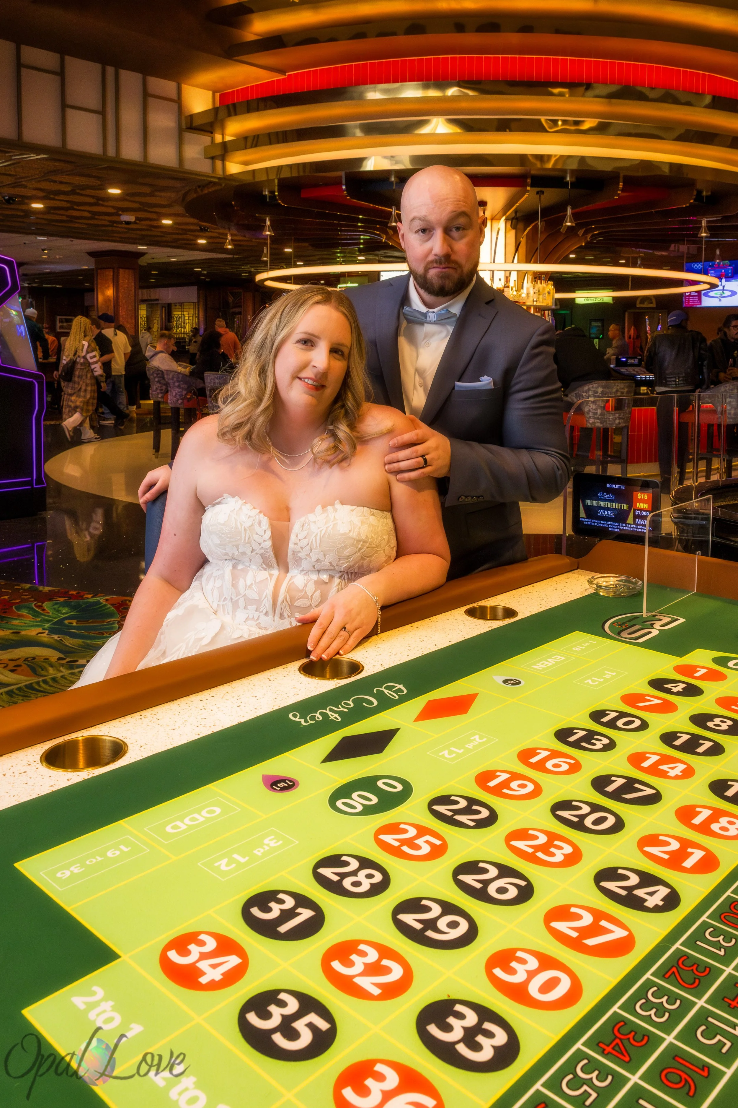 Bride and groom posing at a casino table in downtown Las Vegas after their wedding ceremony.