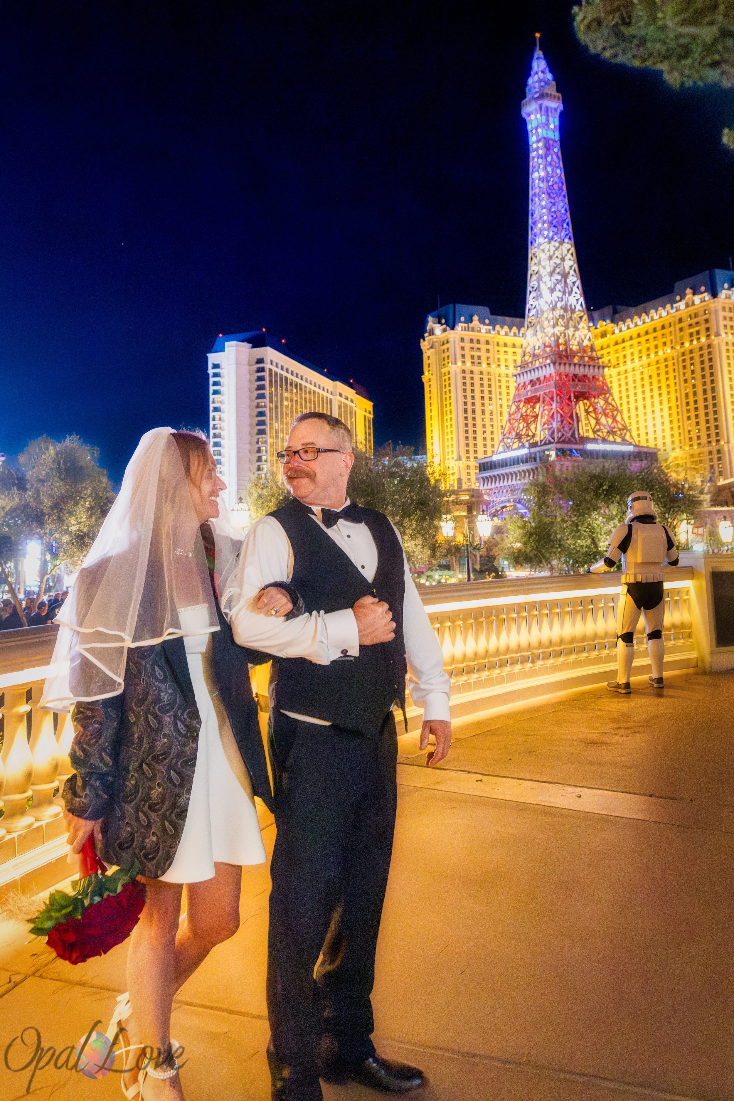 Newly married couple walking together beside the Eiffel Tower at Paris Las Vegas.