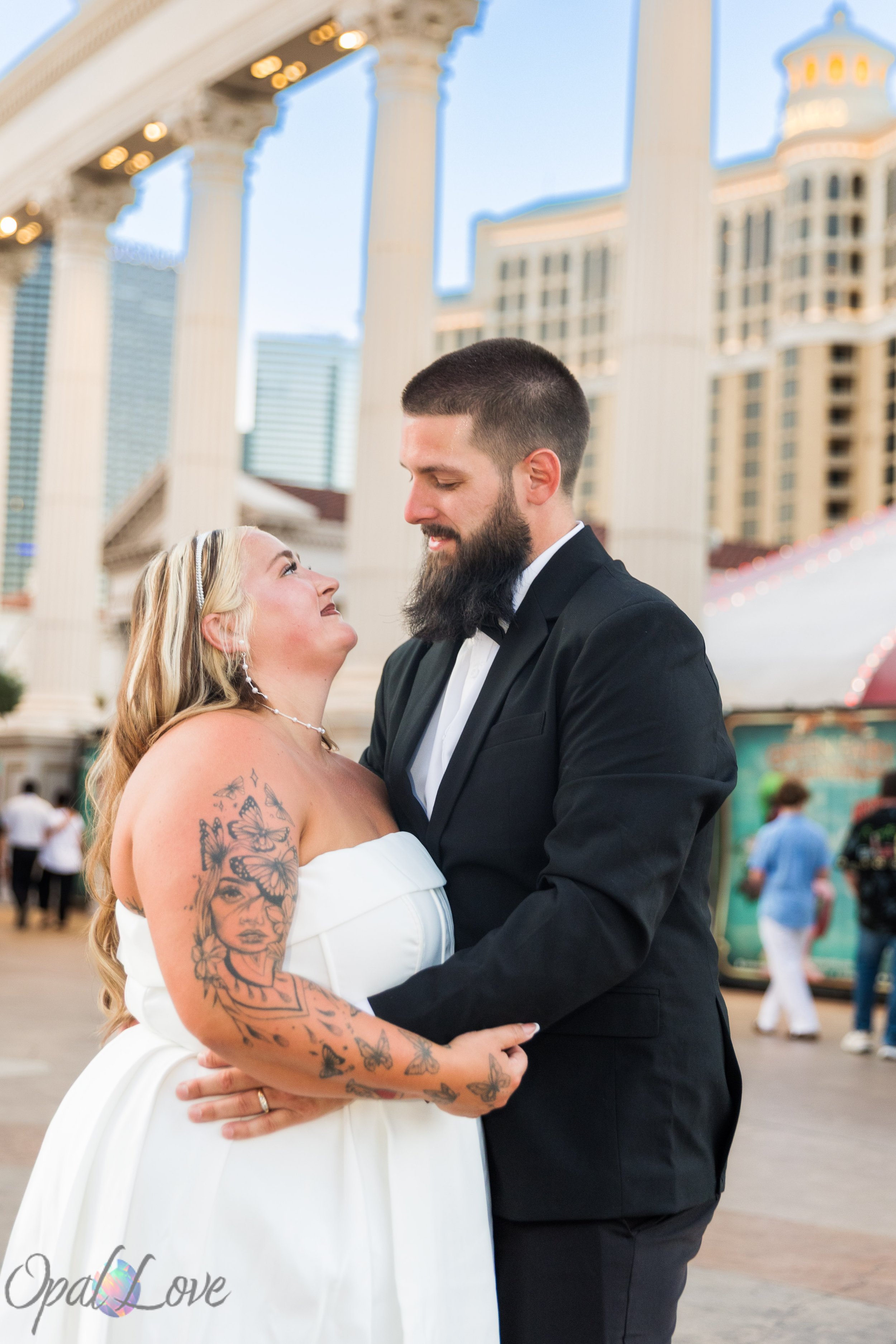 Couple embracing beneath the columns at Caesars Palace during their Las Vegas Strip anniversary photo session.