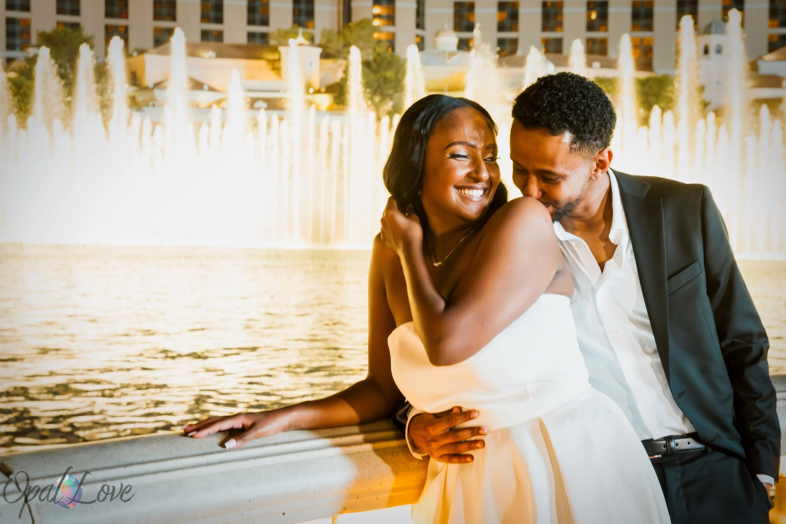 Menna and Yoseph kissing in front of the Bellagio Fountains during their nighttime Las Vegas wedding photography session.