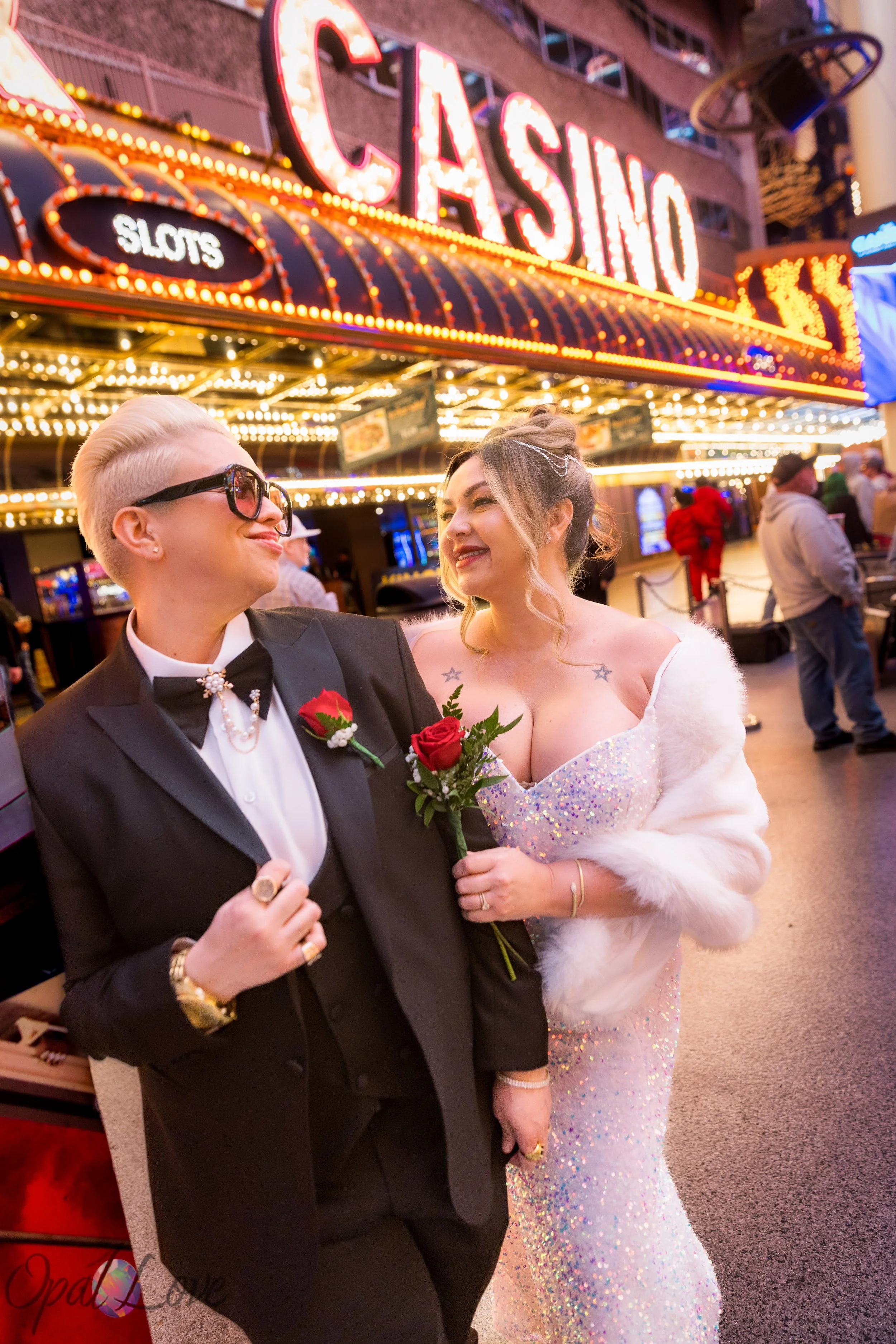 Couple posing in front of the glowing Casino sign on Fremont Street during a Las Vegas anniversary photo session.
