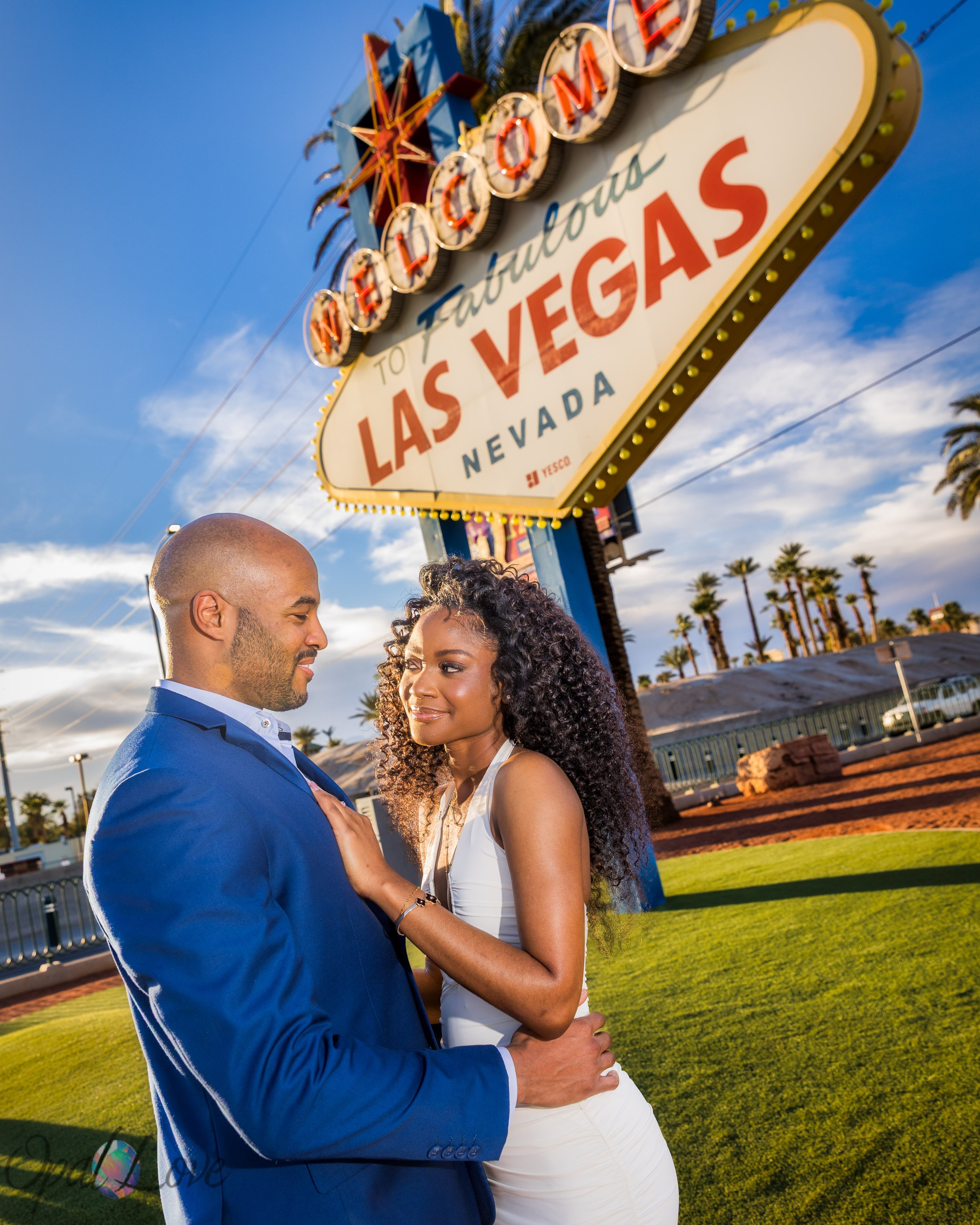 Couple embracing beneath the Welcome to Fabulous Las Vegas sign.