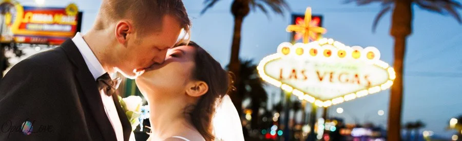 Couple kissing in front of the Welcome to Fabulous Las Vegas sign.