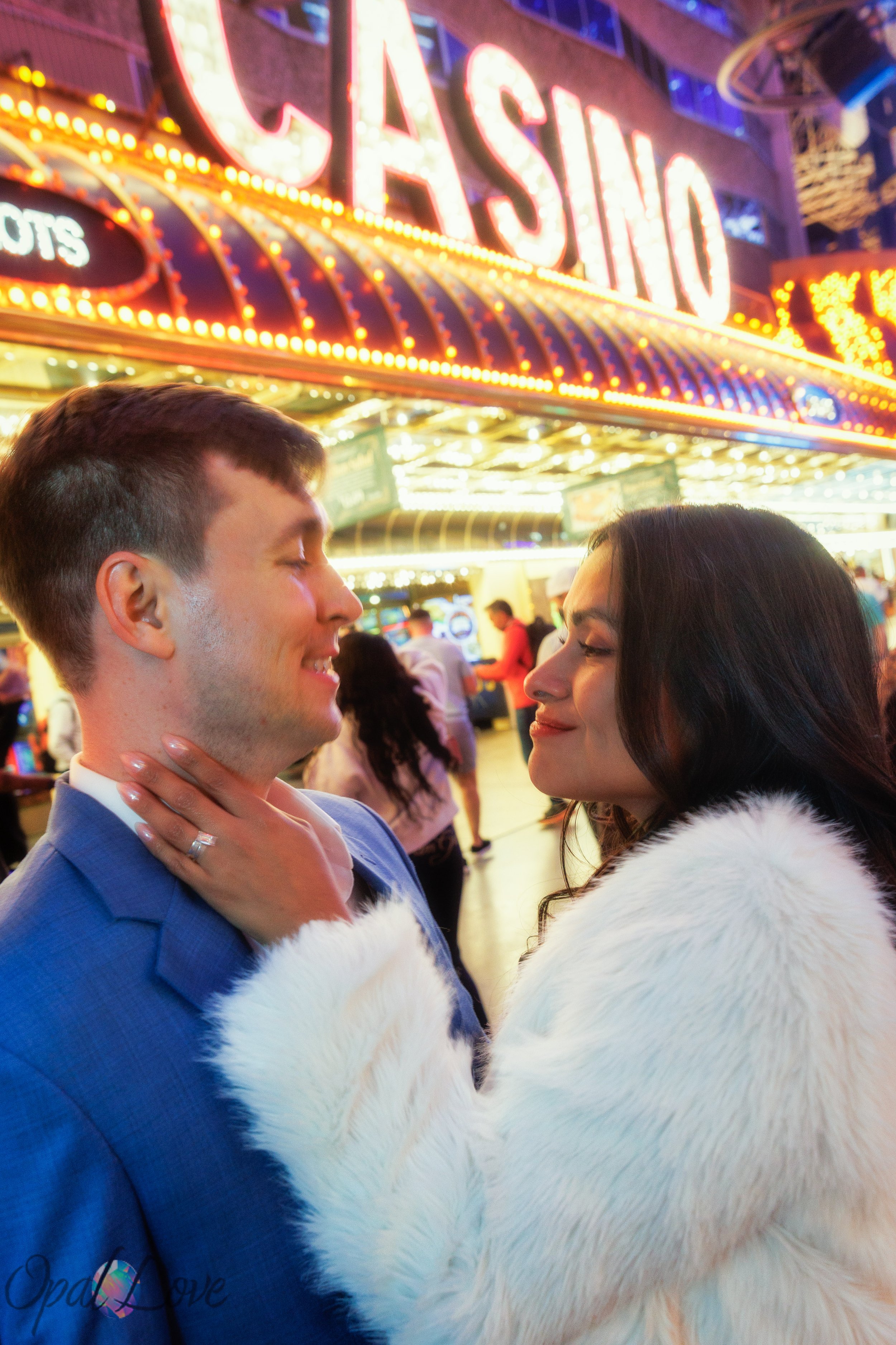 Bride touching groom’s face under bright casino lights in Downtown Las Vegas