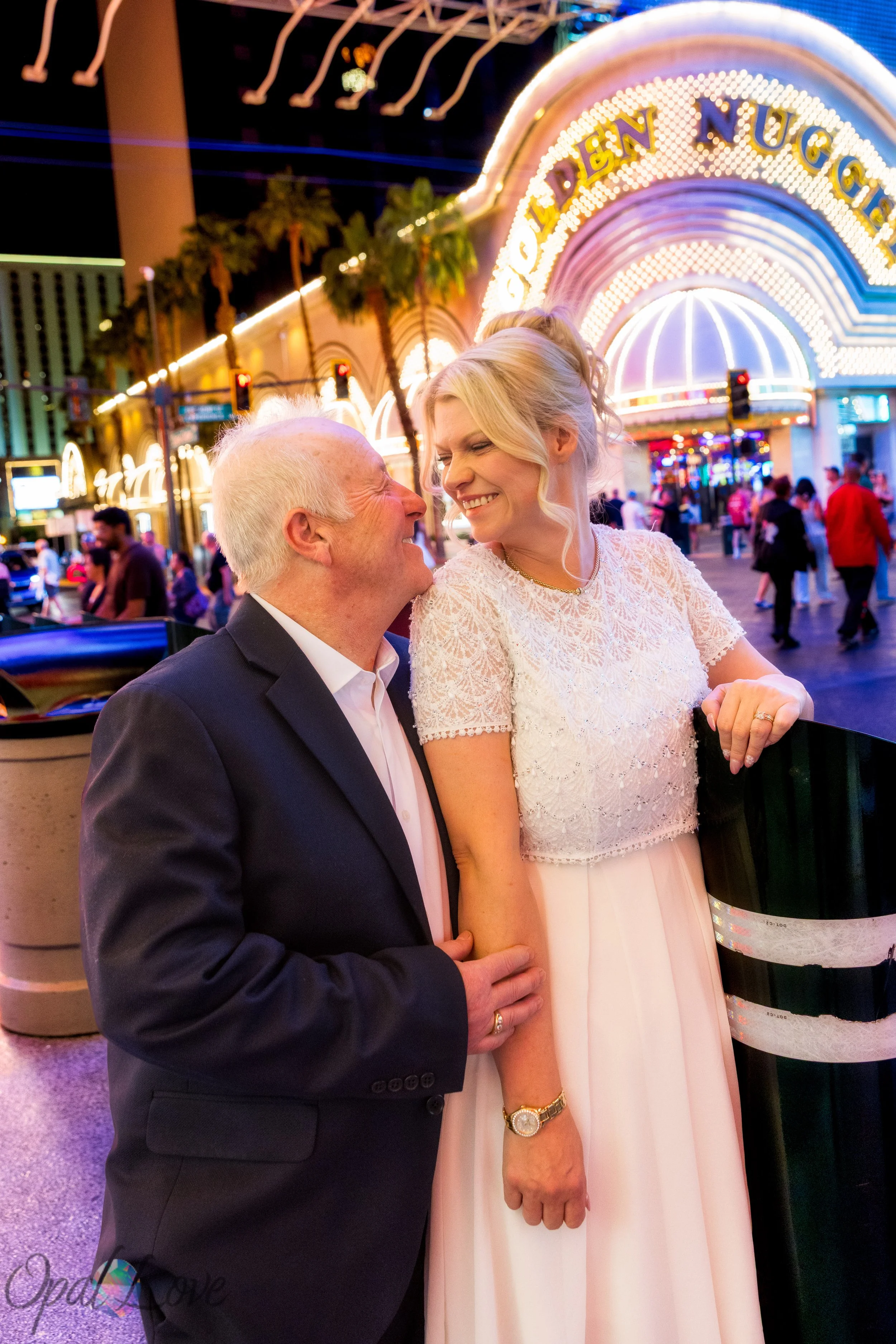 Newlyweds smiling together outside the Golden Nugget on Fremont Street in Las Vegas.