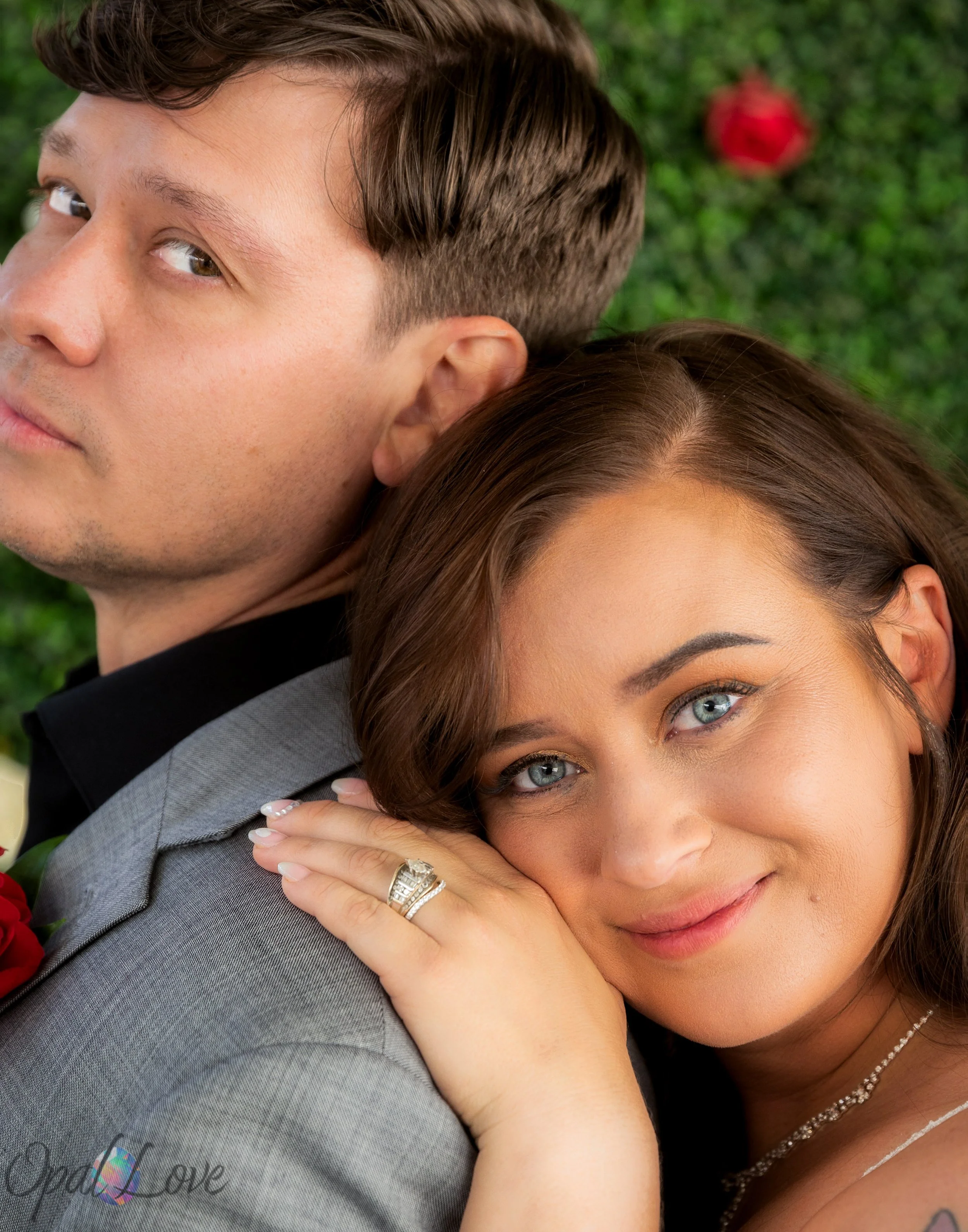 Bride resting her head on her partner’s shoulder, with her wedding ring visible on her hand.
