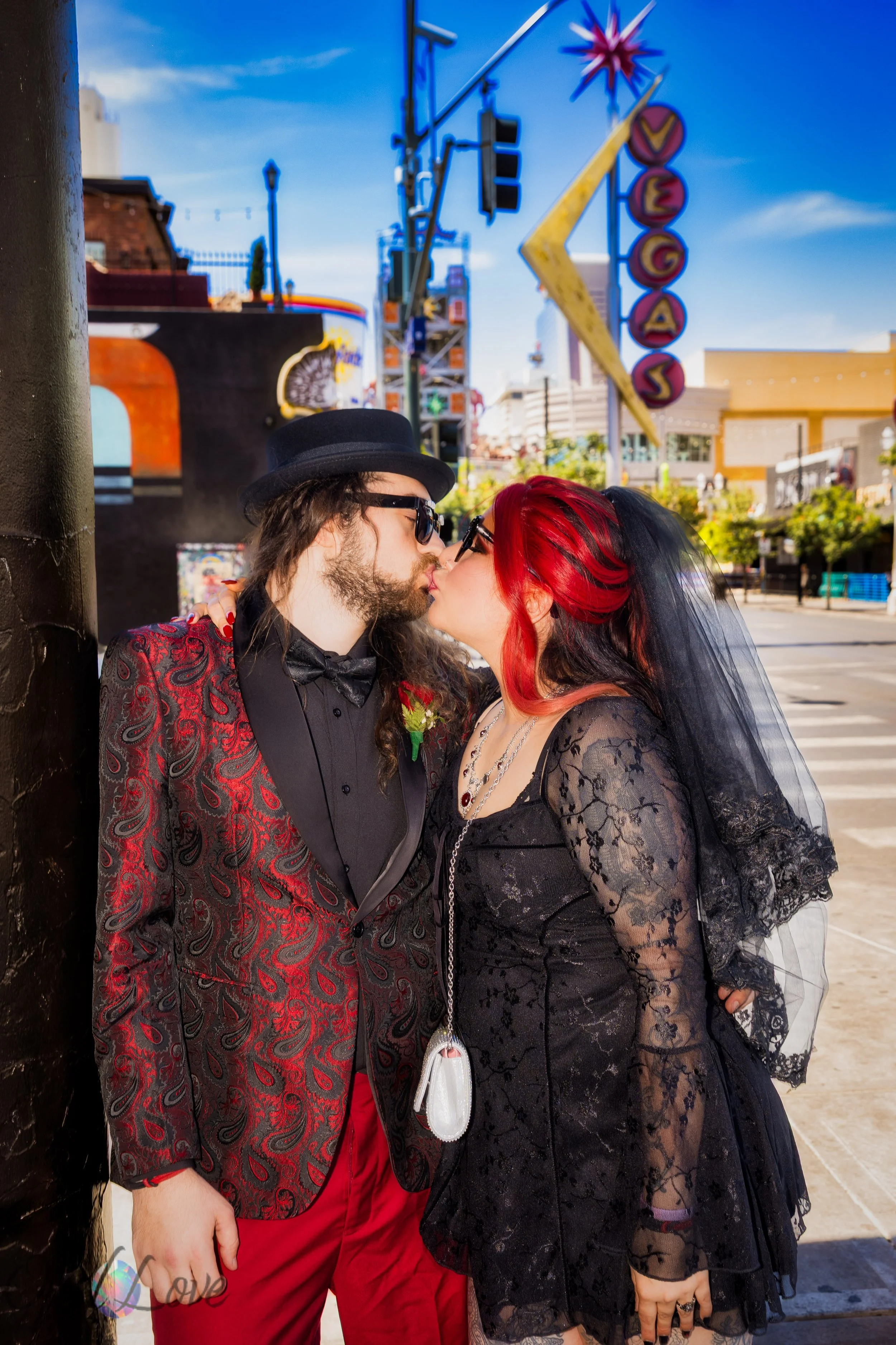 Newly married couple kissing beneath the Vegas sign on Fremont Street in Downtown Las Vegas