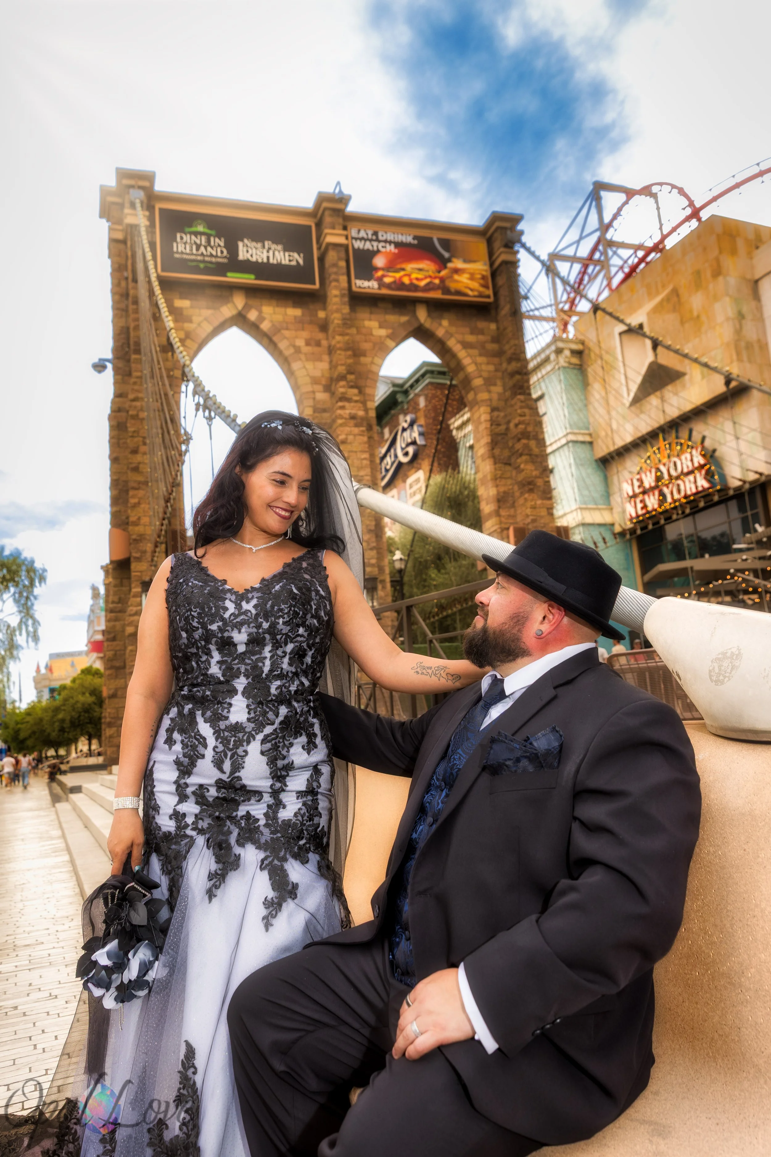 Couple posing beside the Brooklyn Bridge at New York-New York in the South Strip walking zone.