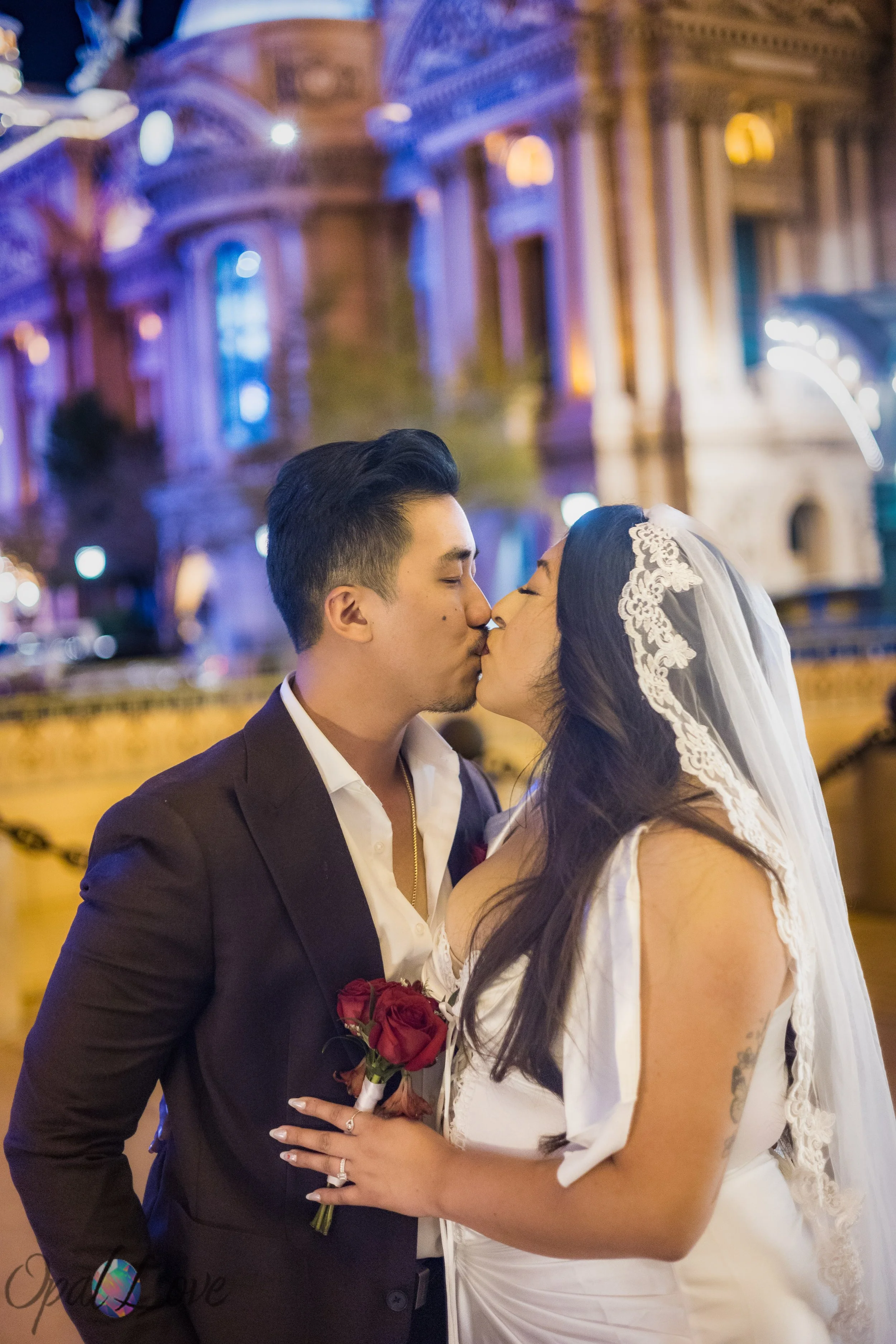 Bride and groom kissing during their romantic nighttime Las Vegas Strip elopement photo session.