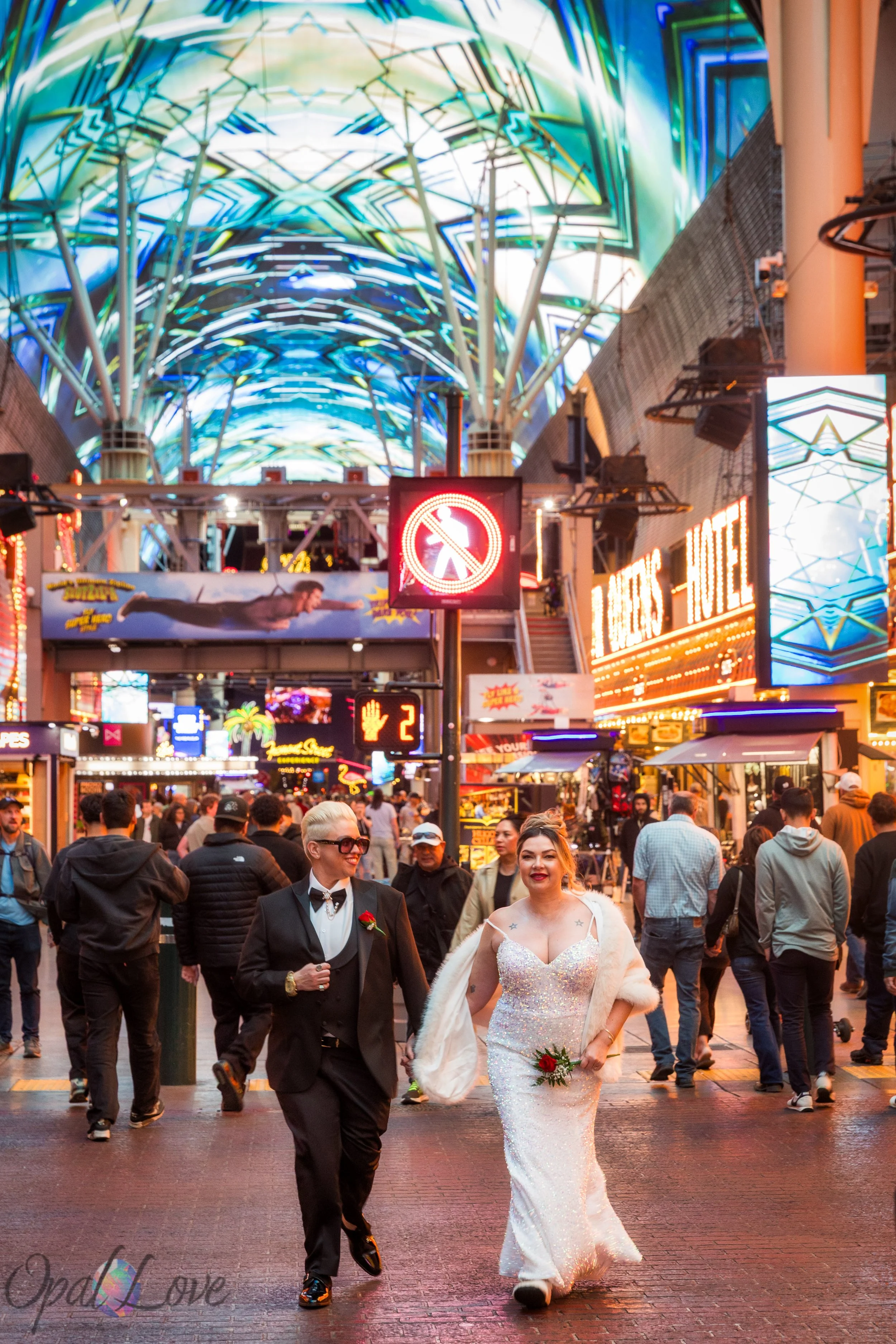 Married couple walking through the Fremont Street Experience crowd beneath the LED canopy in Las Vegas.