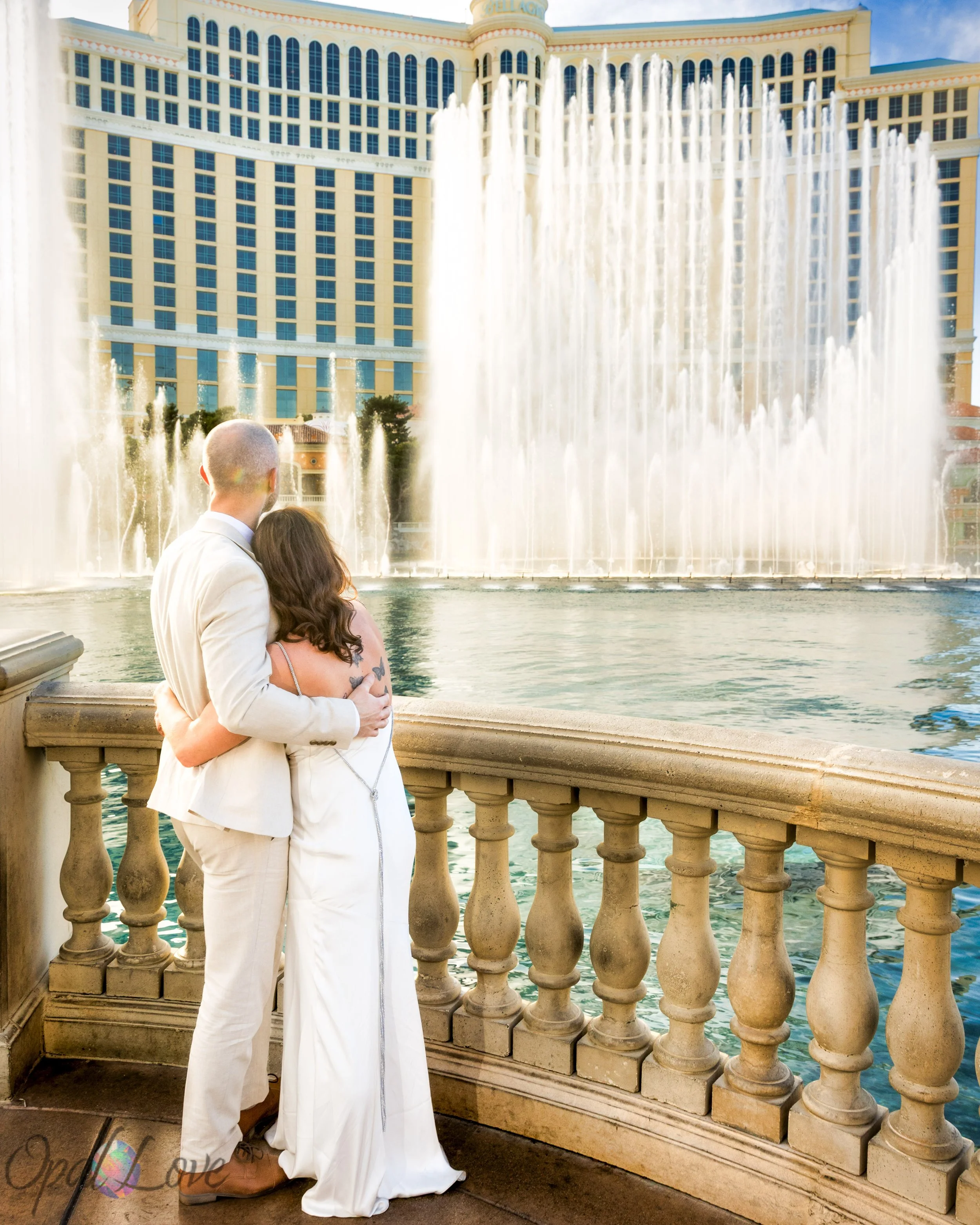 Couple with their arms around each other watching the Bellagio fountains.