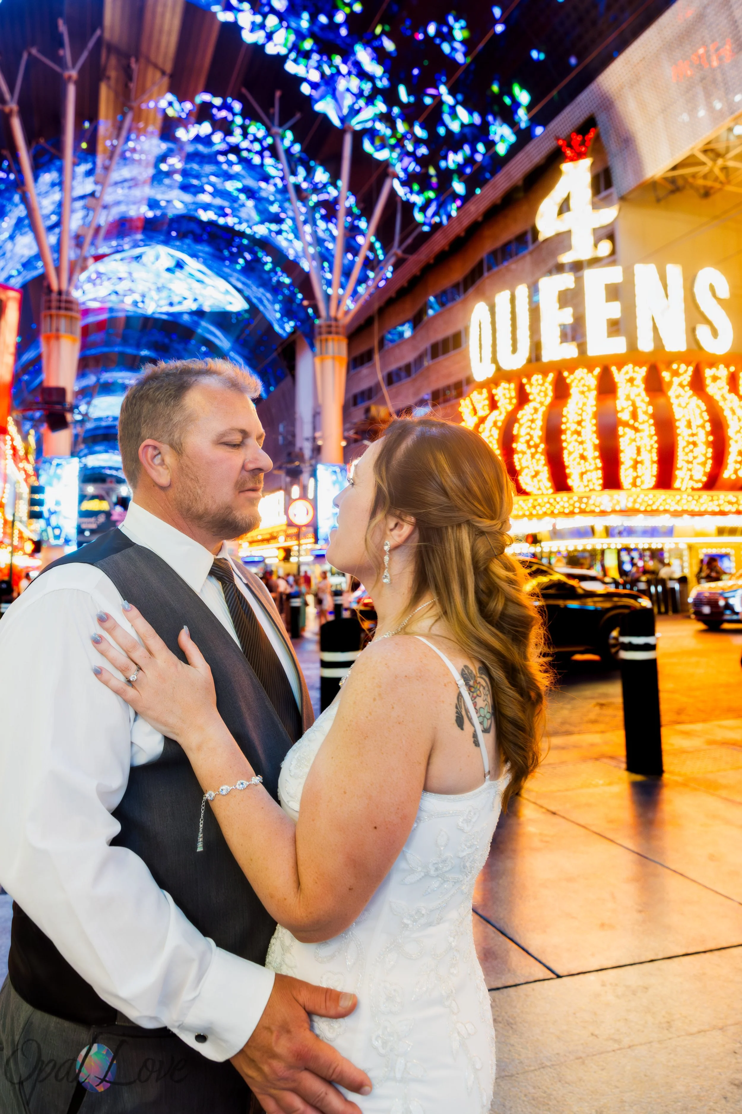 Wedding portrait near the historic Four Queens casino sign on Fremont Street in Las Vegas.