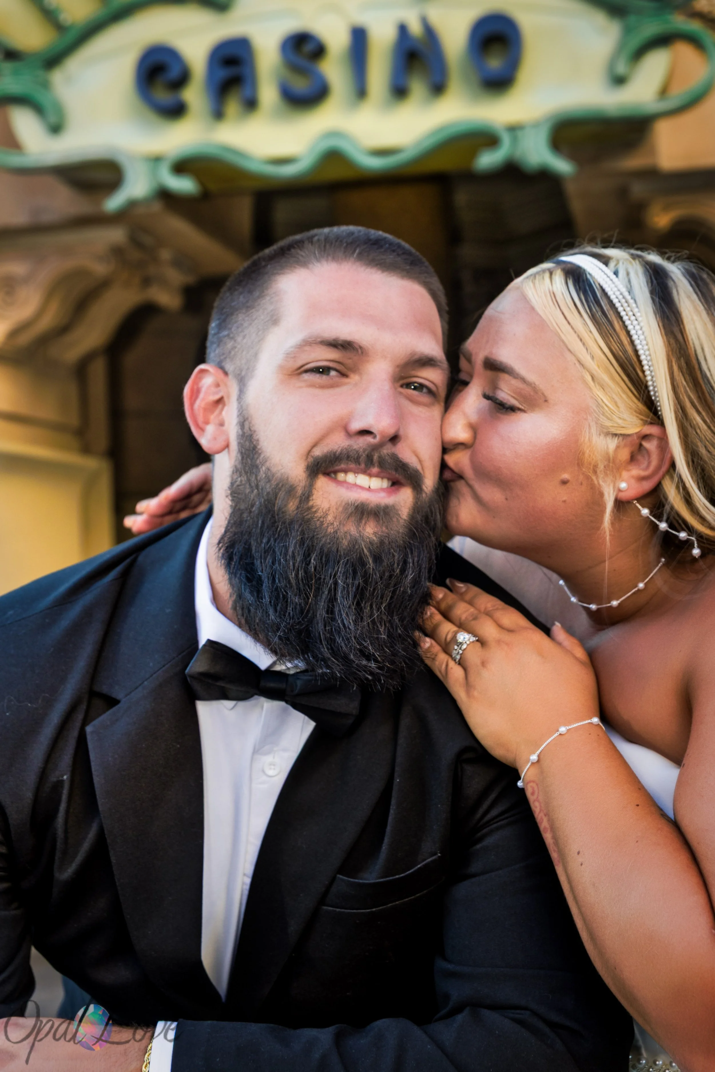 Wife kissing her husband outside Paris Las Vegas during their 10 year anniversary photo session on the Las Vegas Strip.