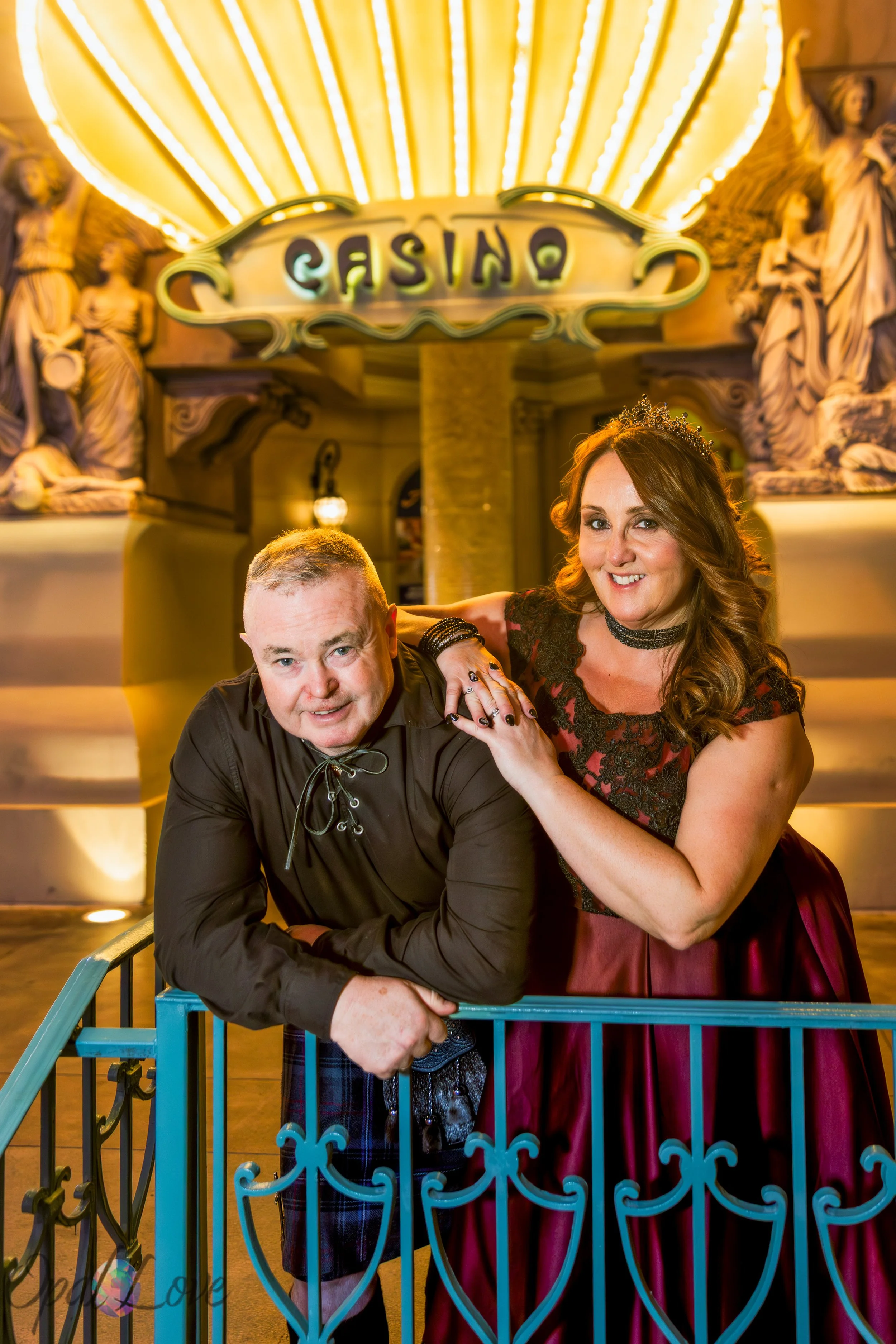 Bride and groom posing beneath illuminated casino architecture at Paris Las Vegas after their wedding.