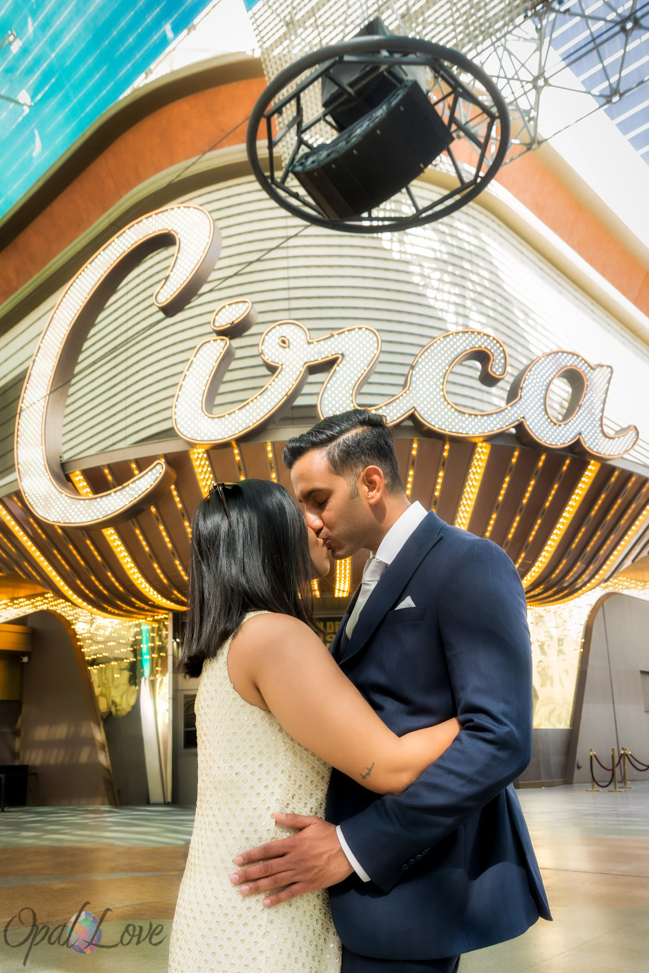 Bride and groom sharing a kiss in front of the Circa Hotel entrance lights.