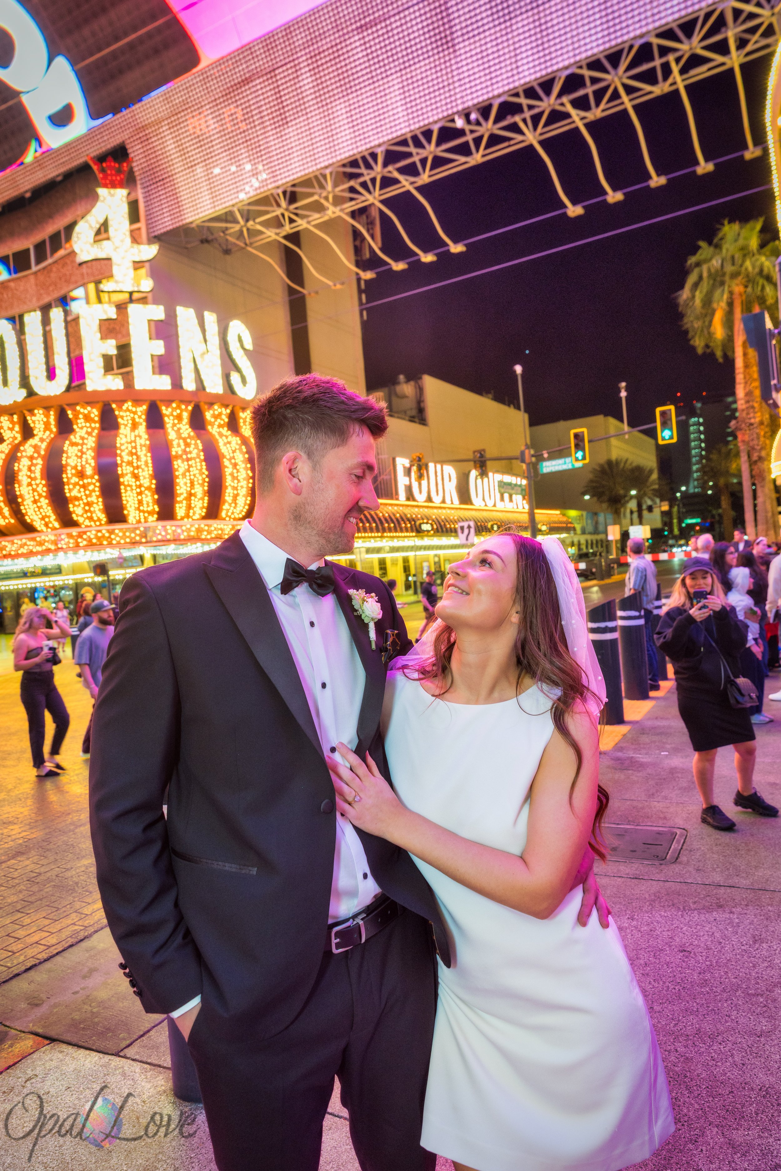 Couple smiling with Four Queens casino lights in Downtown Las Vegas