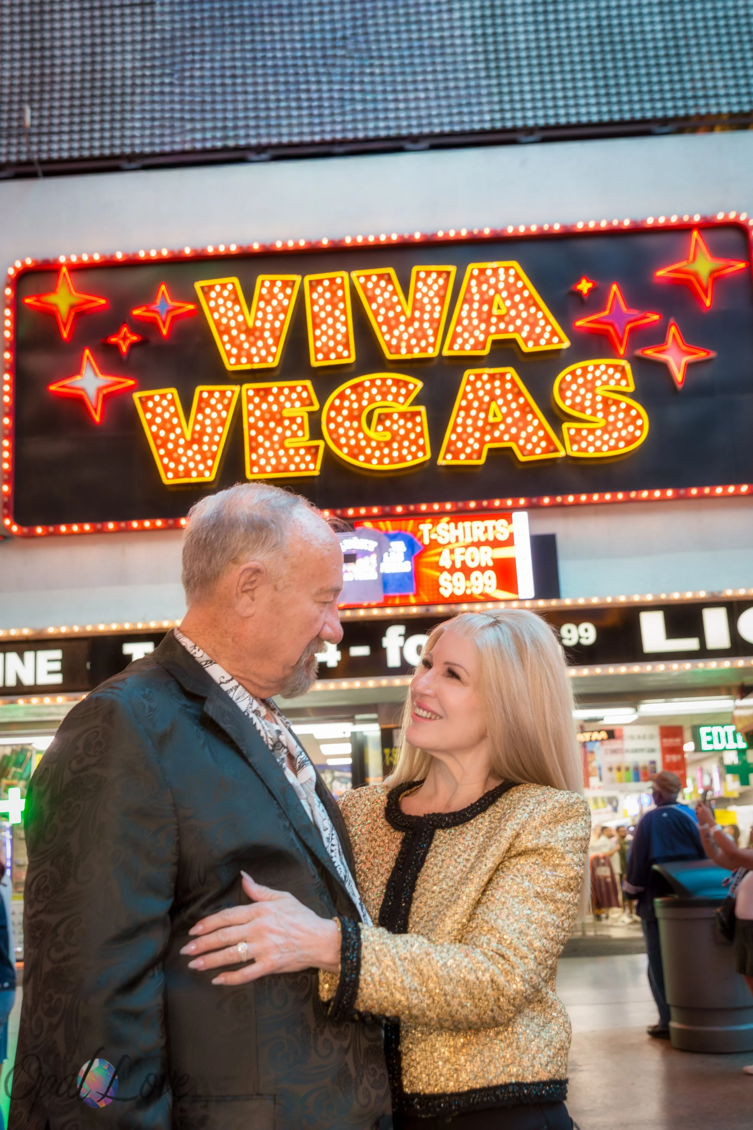 Couple embracing in front of the Viva Vegas marquee on Fremont Street.