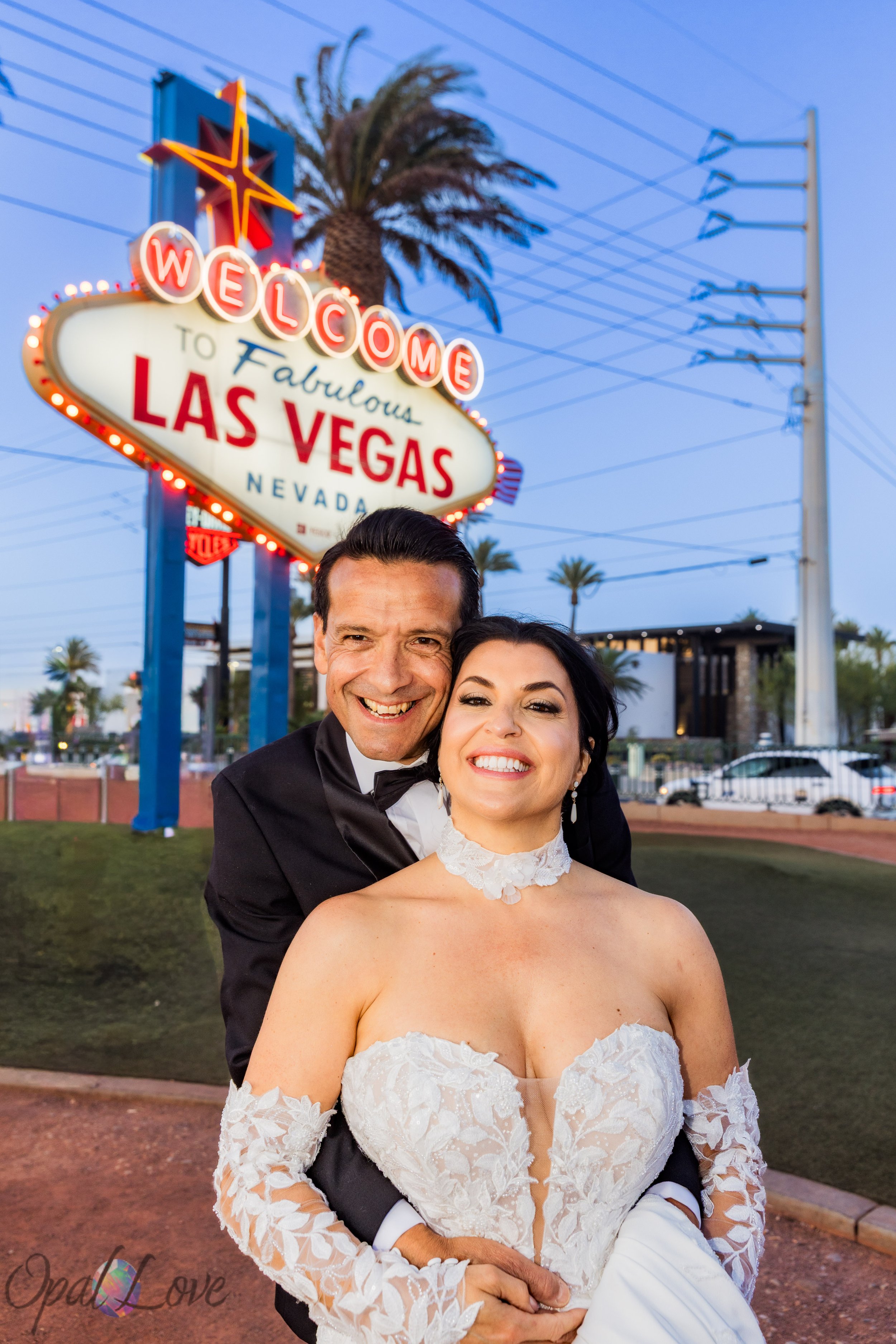 Newlyweds and daughter posing at the Welcome to Las Vegas Sign