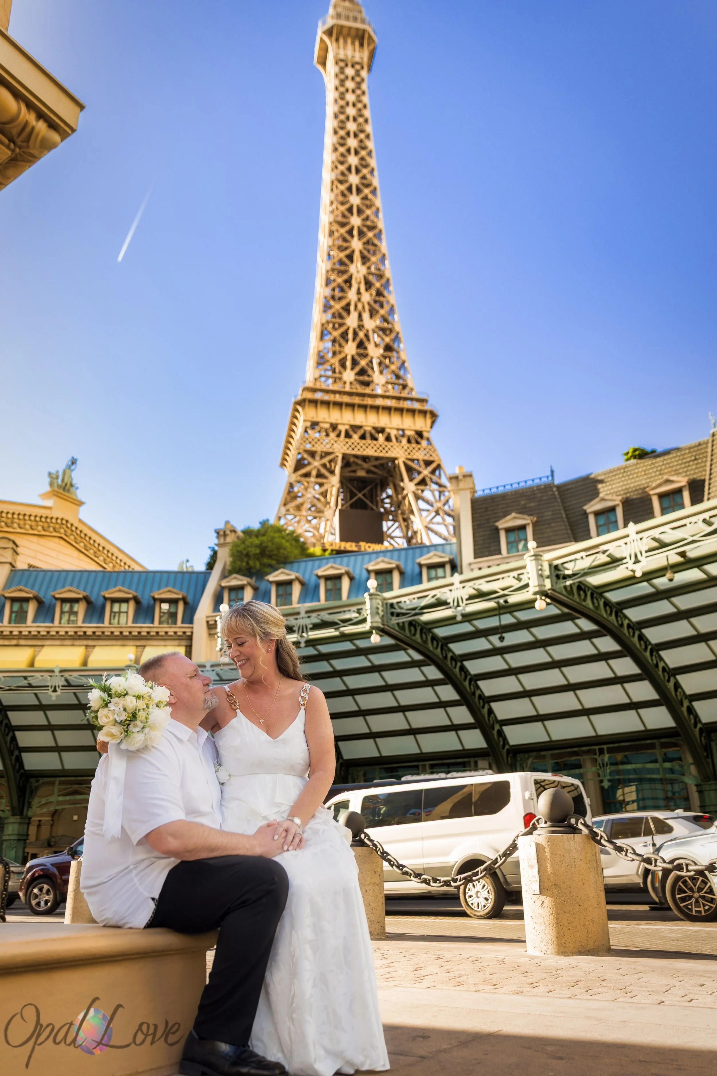 Couple sitting near the Eiffel Tower at Paris Las Vegas during their fun and relaxed elopement photo session.