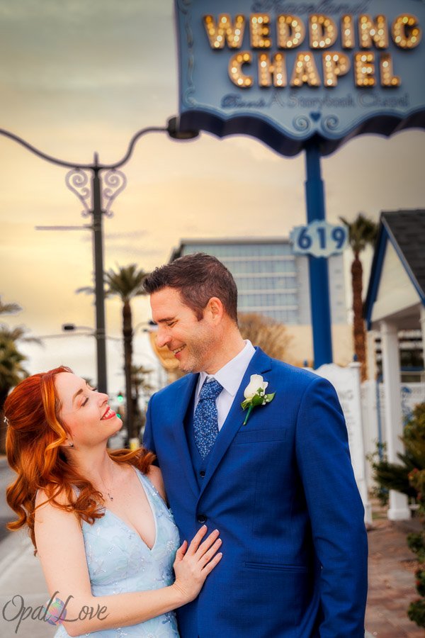 Newlywed couple smiling together outside Graceland Wedding Chapel in Las Vegas.