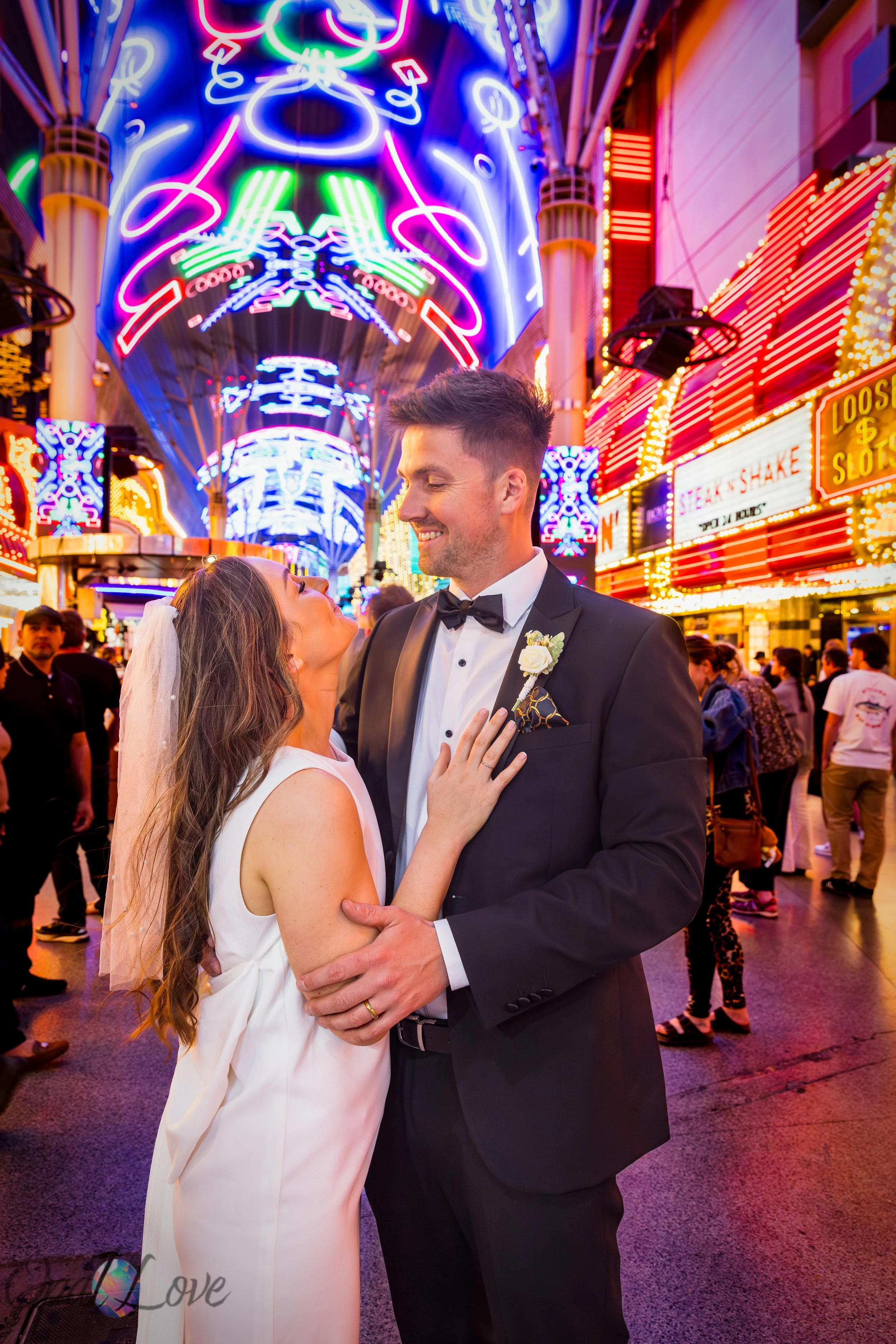 Couple embracing beneath colorful Fremont Street Experience neon canopy