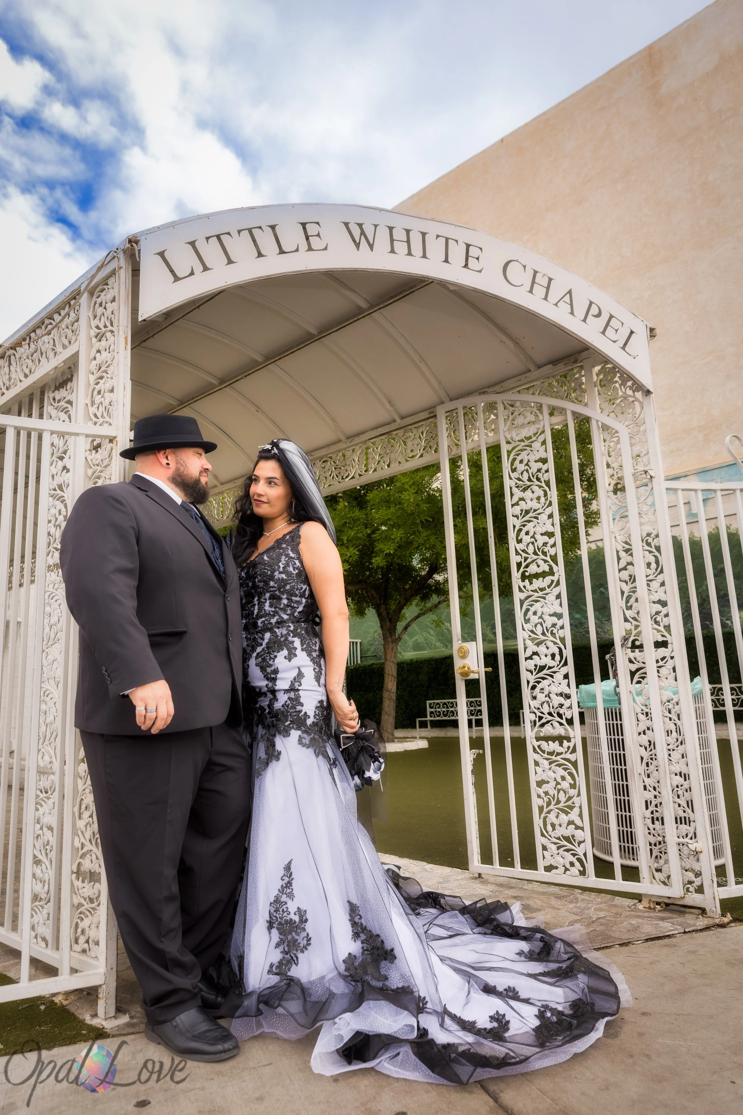 Couple posing under the white archway at the Little White Chapel.