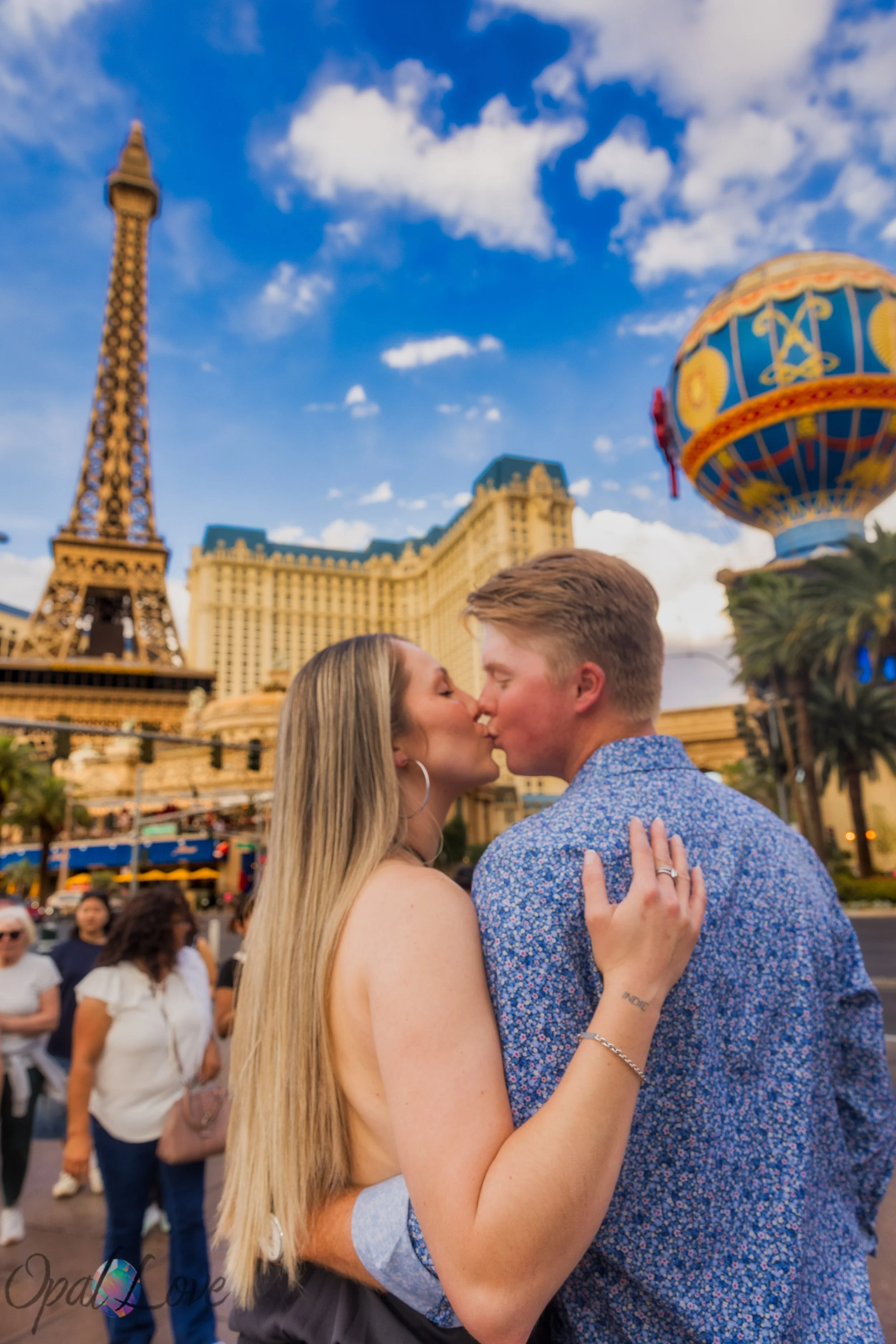 Couple kissing with Bellagio fountains and Paris Las Vegas behind them