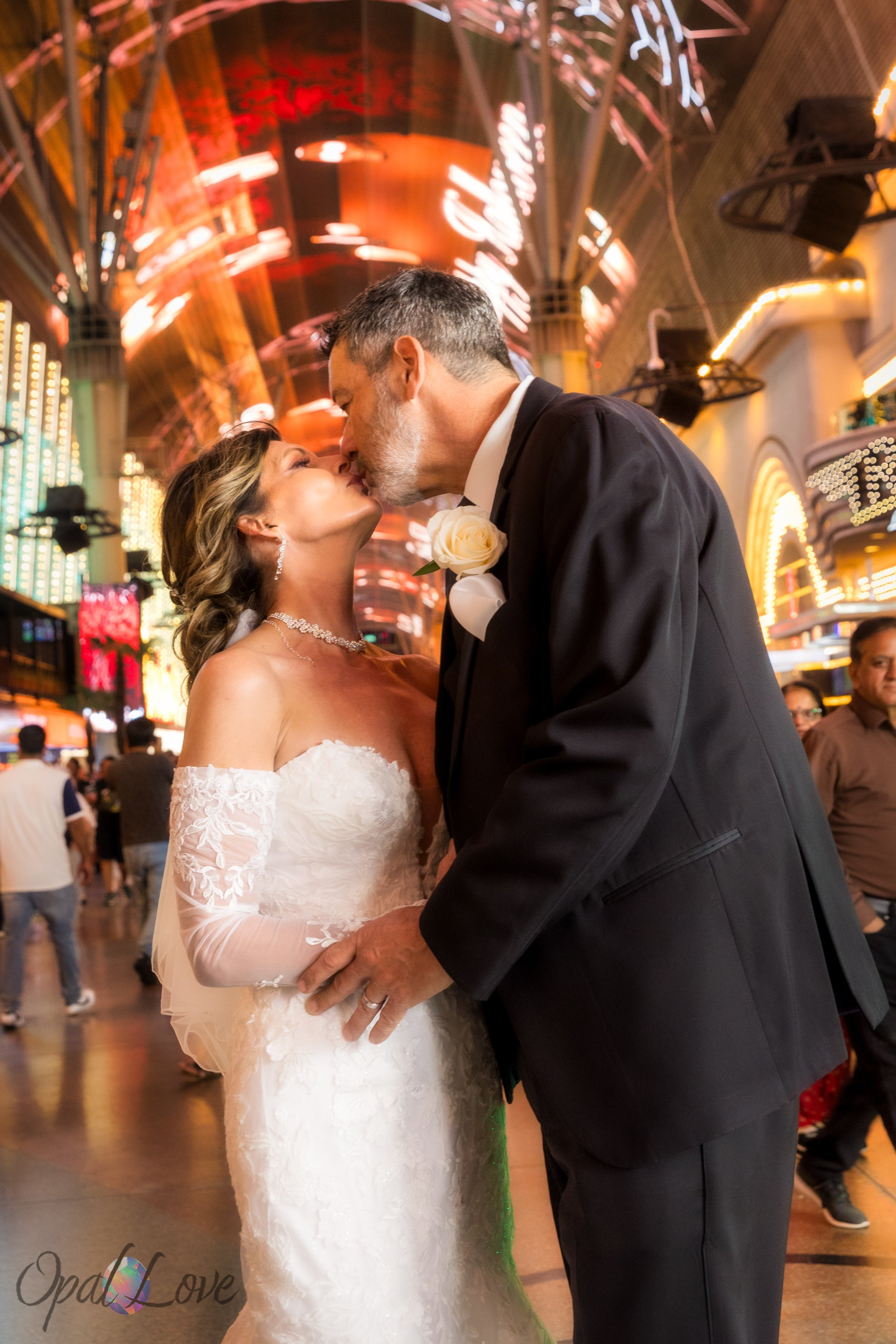 Couple kissing under the bright canopy of Fremont Street during their Las Vegas elopement.