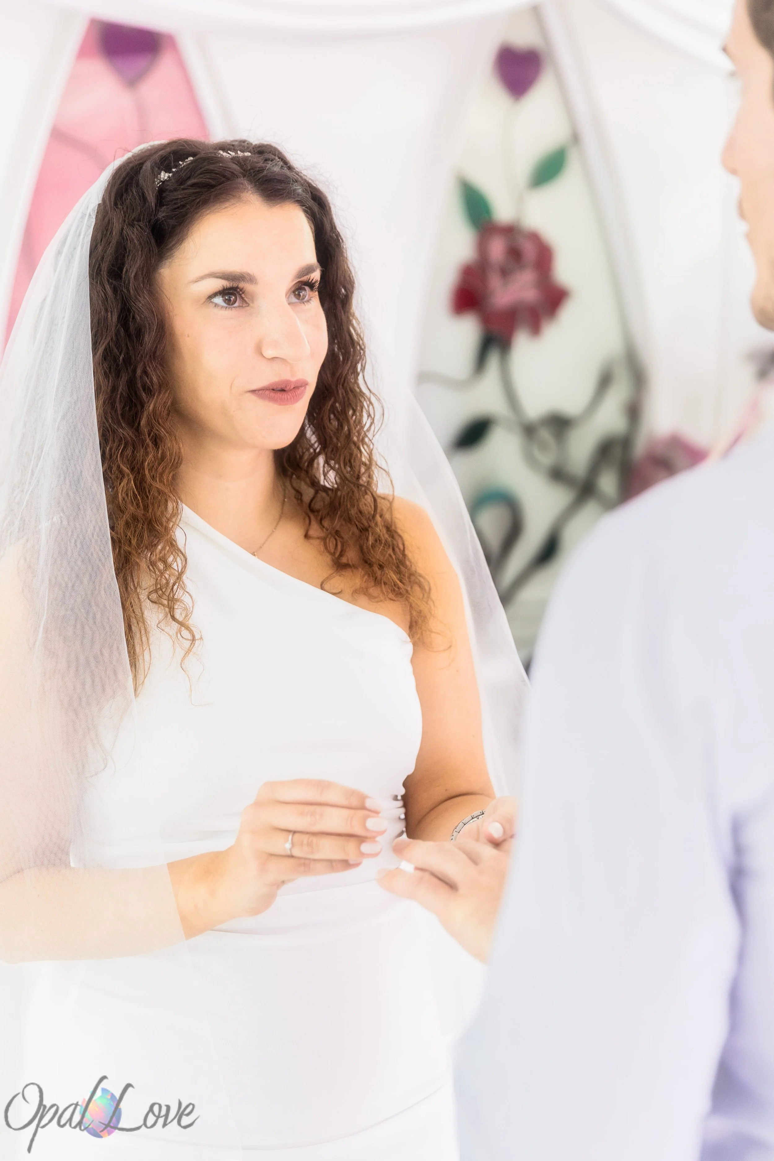 

Bride looking at her partner as they exchange rings during their chapel ceremony.