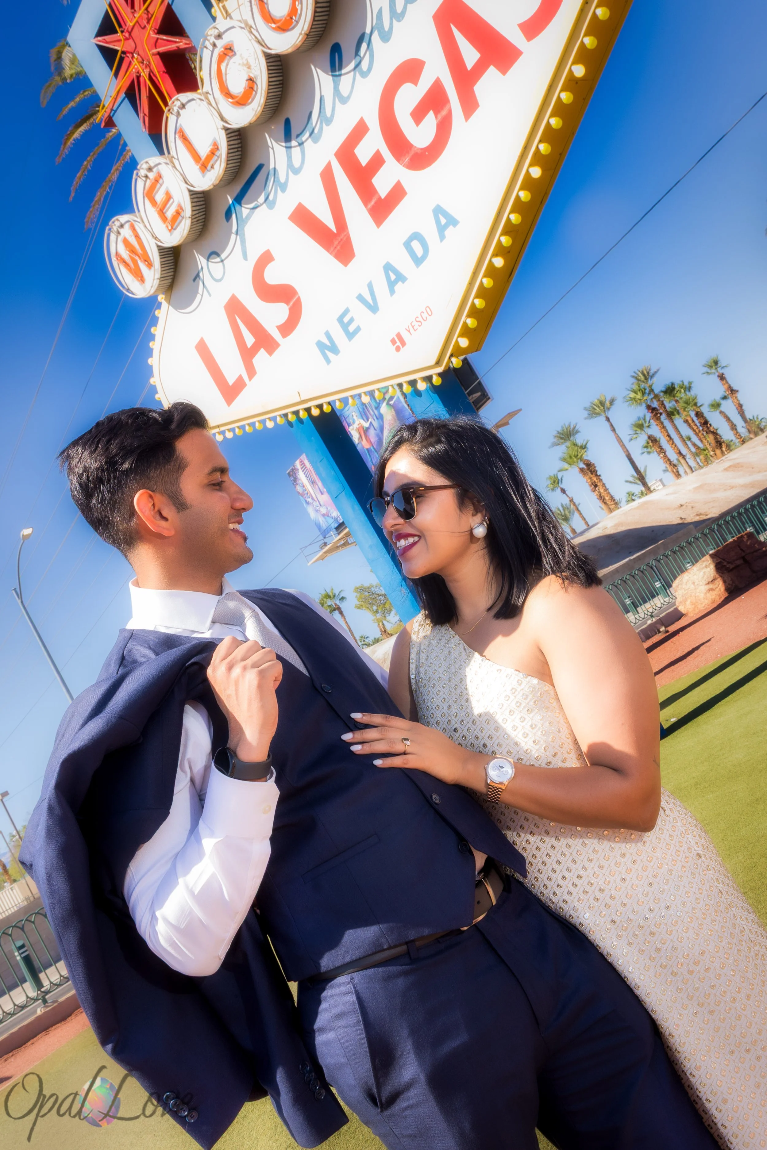 Couple laughing together at the Welcome to Fabulous Las Vegas Sign after their courthouse elopement.