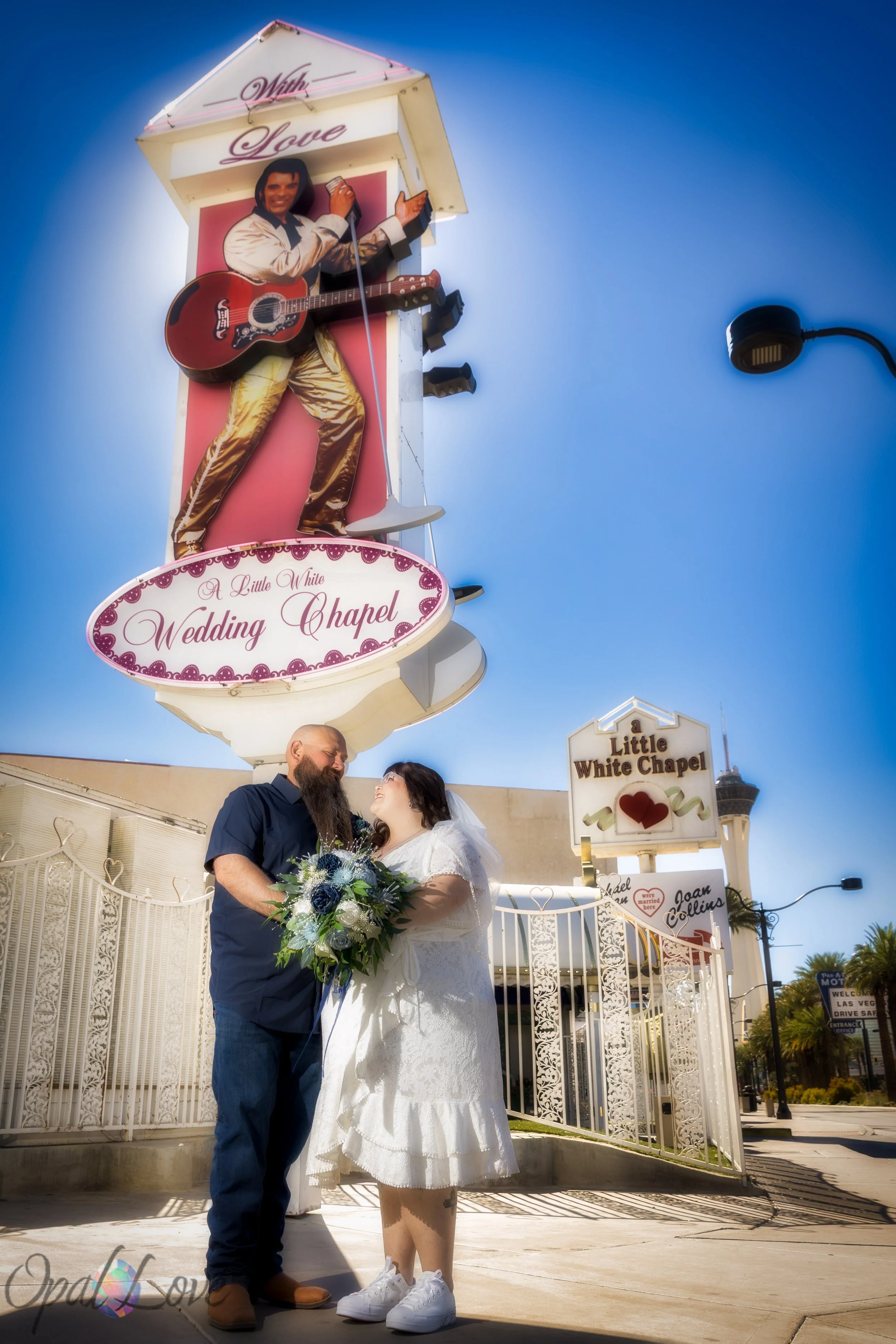 Couple standing beneath the Elvis sign at A Little White Chapel during their Las Vegas elopement.