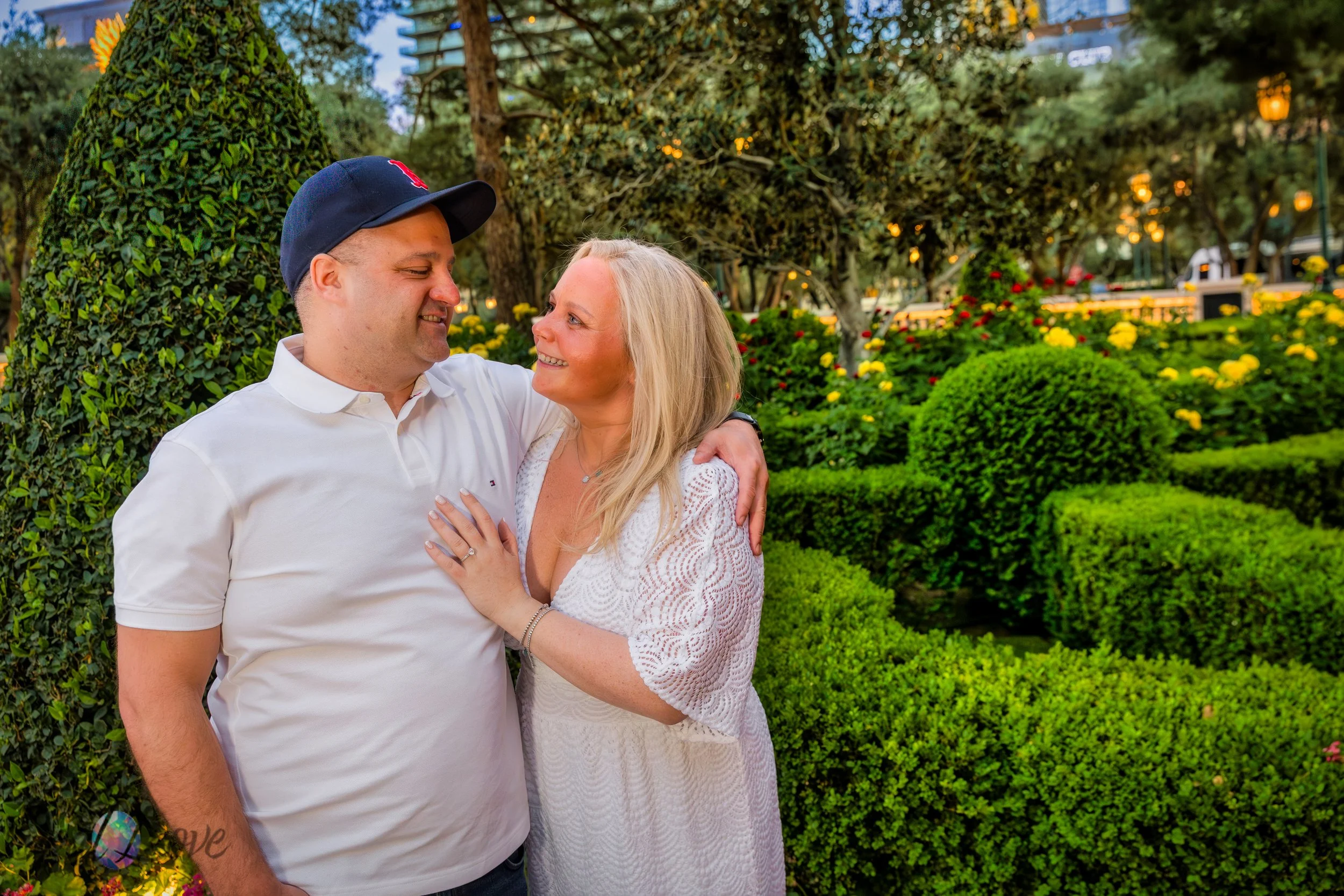 Couple smiling together in lush Bellagio gardens during a Las Vegas engagement session.