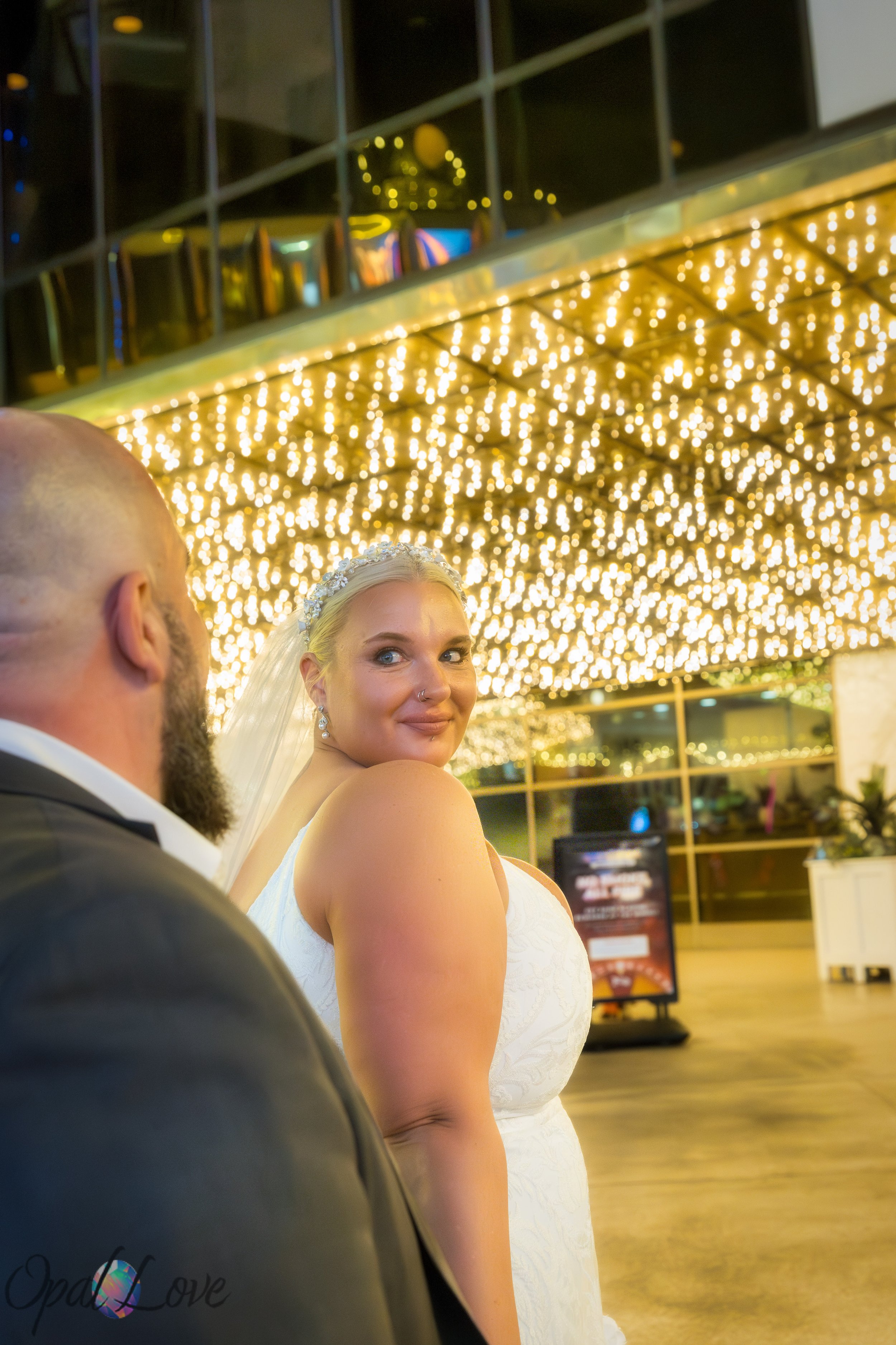 Bride turning back under golden canopy lights on Fremont Street.