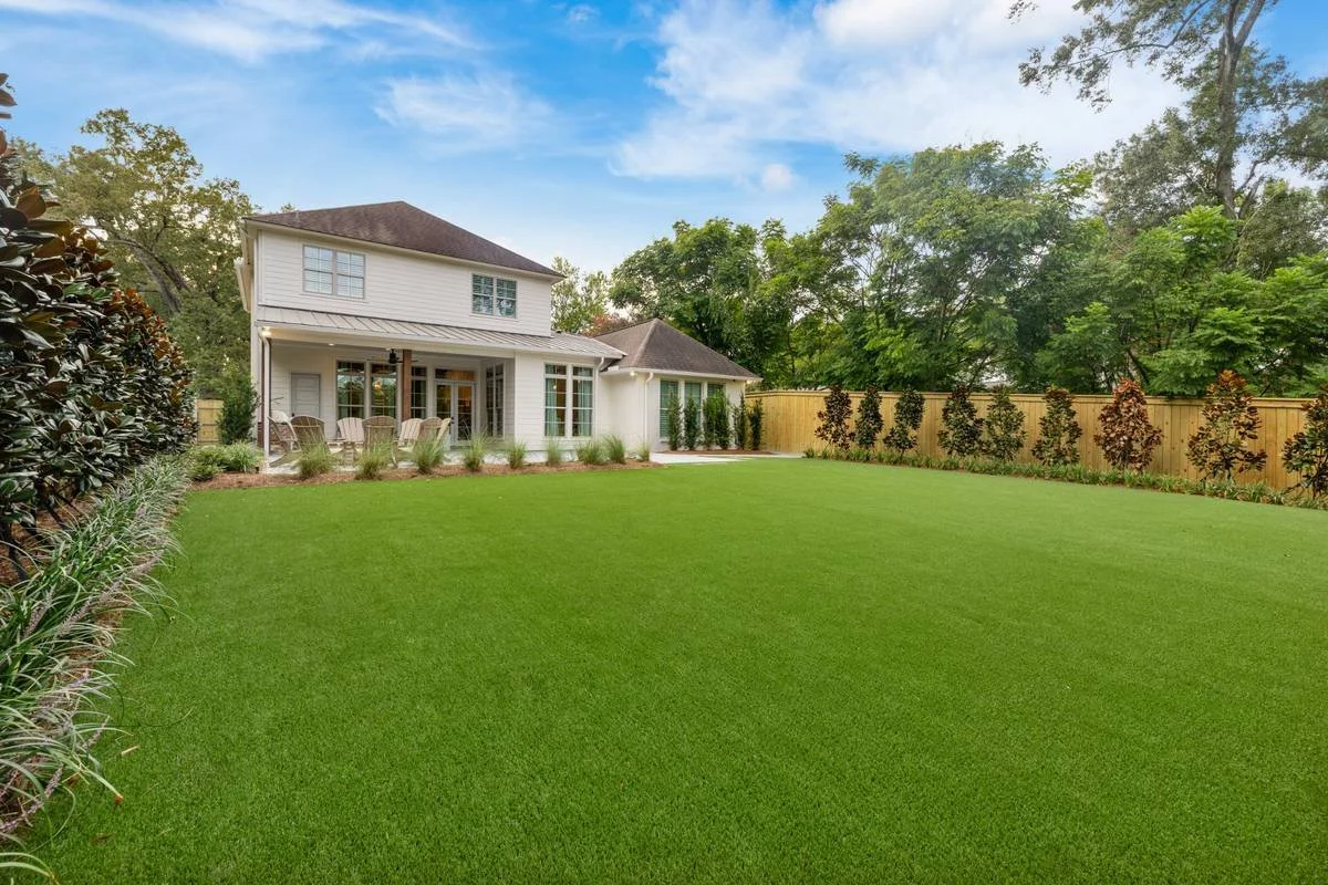Synthetic lawn leading to the covered patio at the back of the home — Flora Landscape Contractors