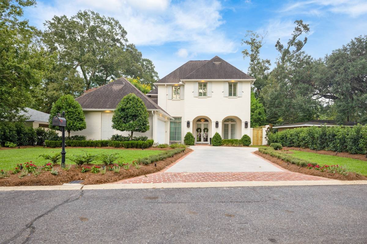 Front yard with planted beds and fresh sod along a concrete driveway — Flora Landscape Contractors