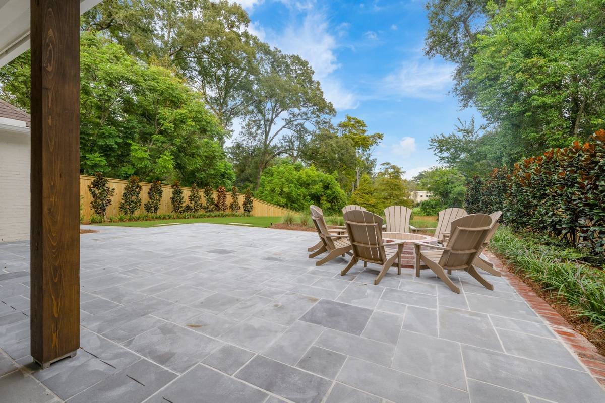 View of the bluestone terrace and fire pit from the covered patio — Flora Landscape Contractors